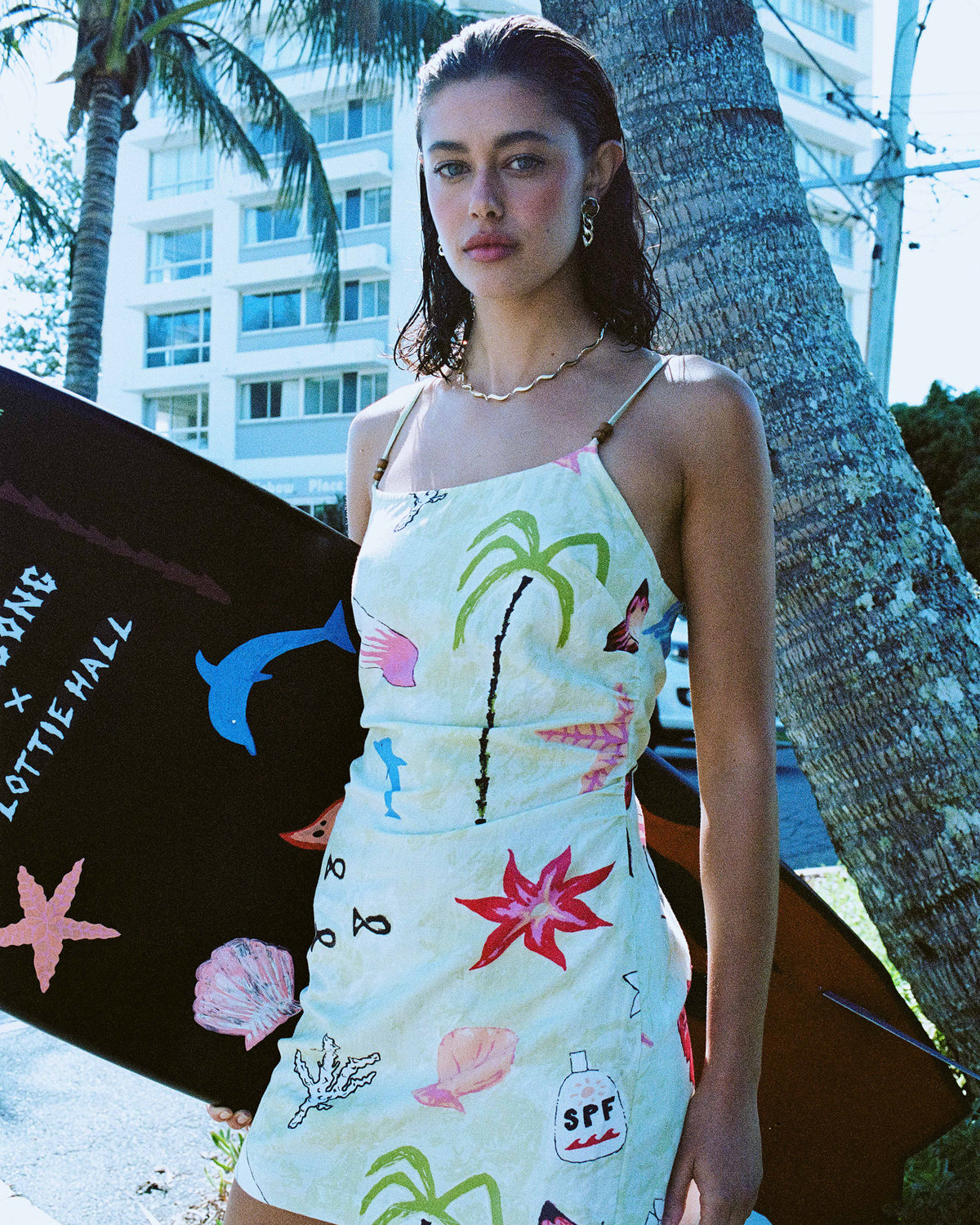 Sleeveless woven dress in pale yellow with colorful marine and tropical print, adjustable straps, fitted waist.