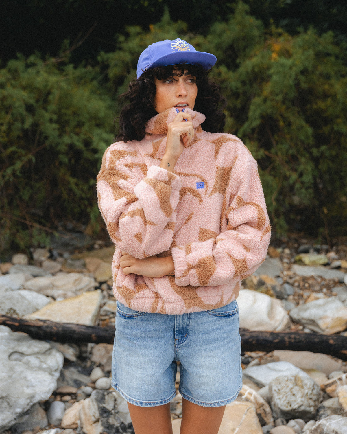 Rose brown and tan patterned half-zip sherpa fleece pullover worn with denim shorts.
