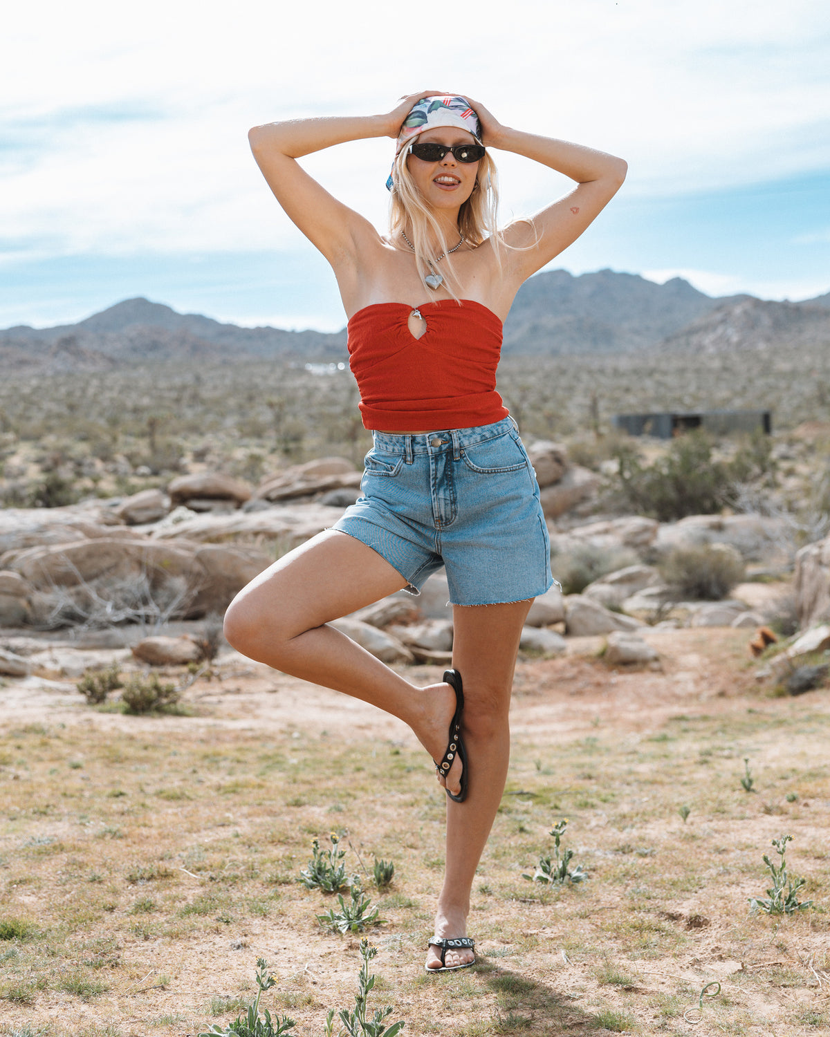 Faded indigo denim cut-off shorts with frayed edges and button-fly closure.