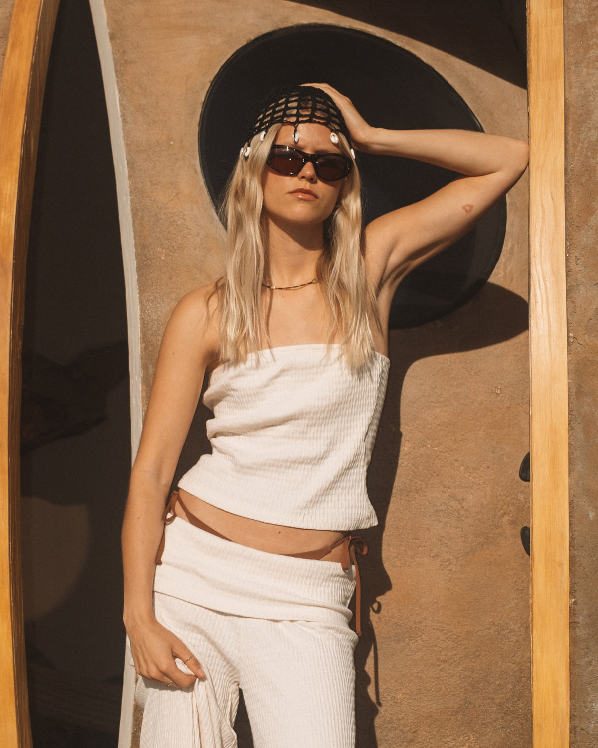 White ribbed tube top with strapless neckline and fitted silhouette.