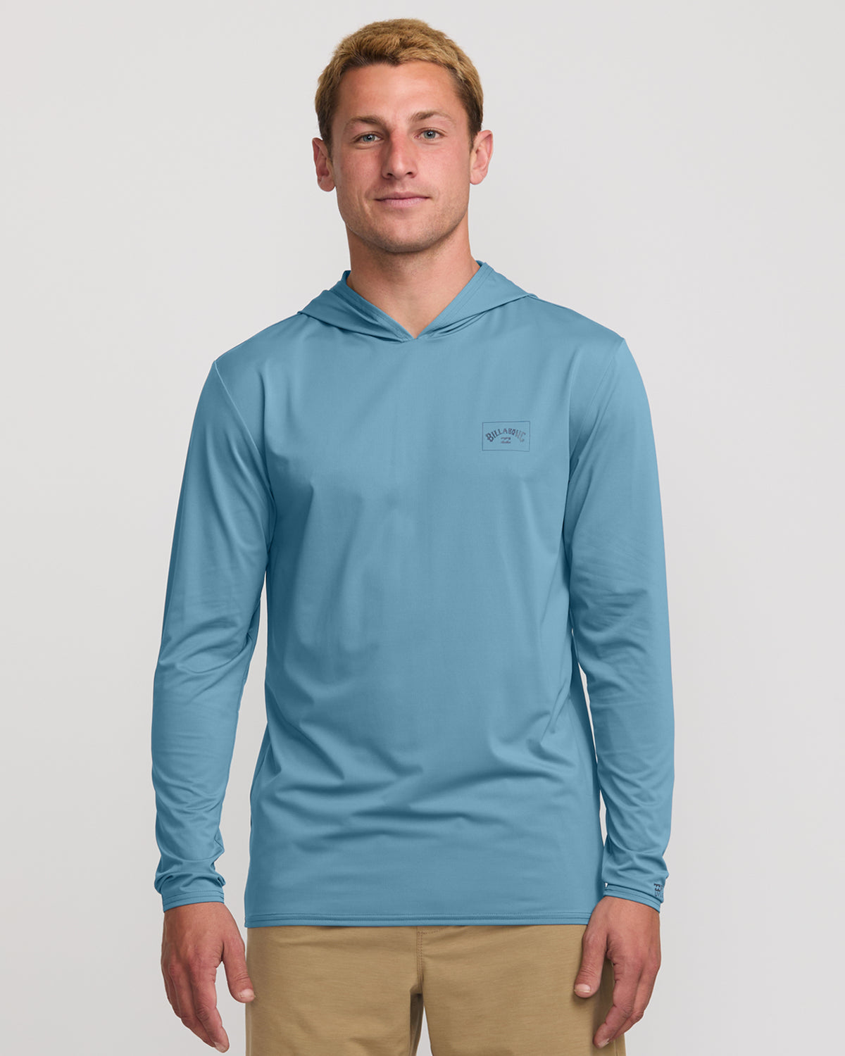Bay blue long sleeve hooded surf tee with small chest logo, worn with khaki shorts.