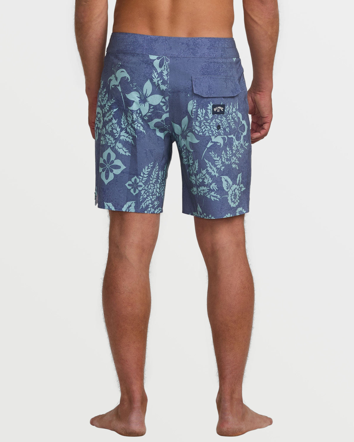 Blue-gray boardshorts with light green floral and botanical print, back view with velcro pocket.
