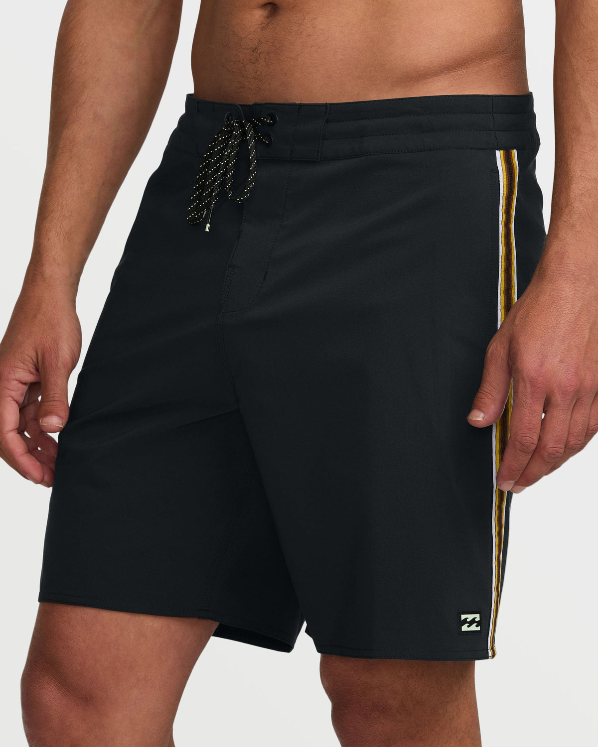 Black boardshorts with gold side stripe and drawstring waist.