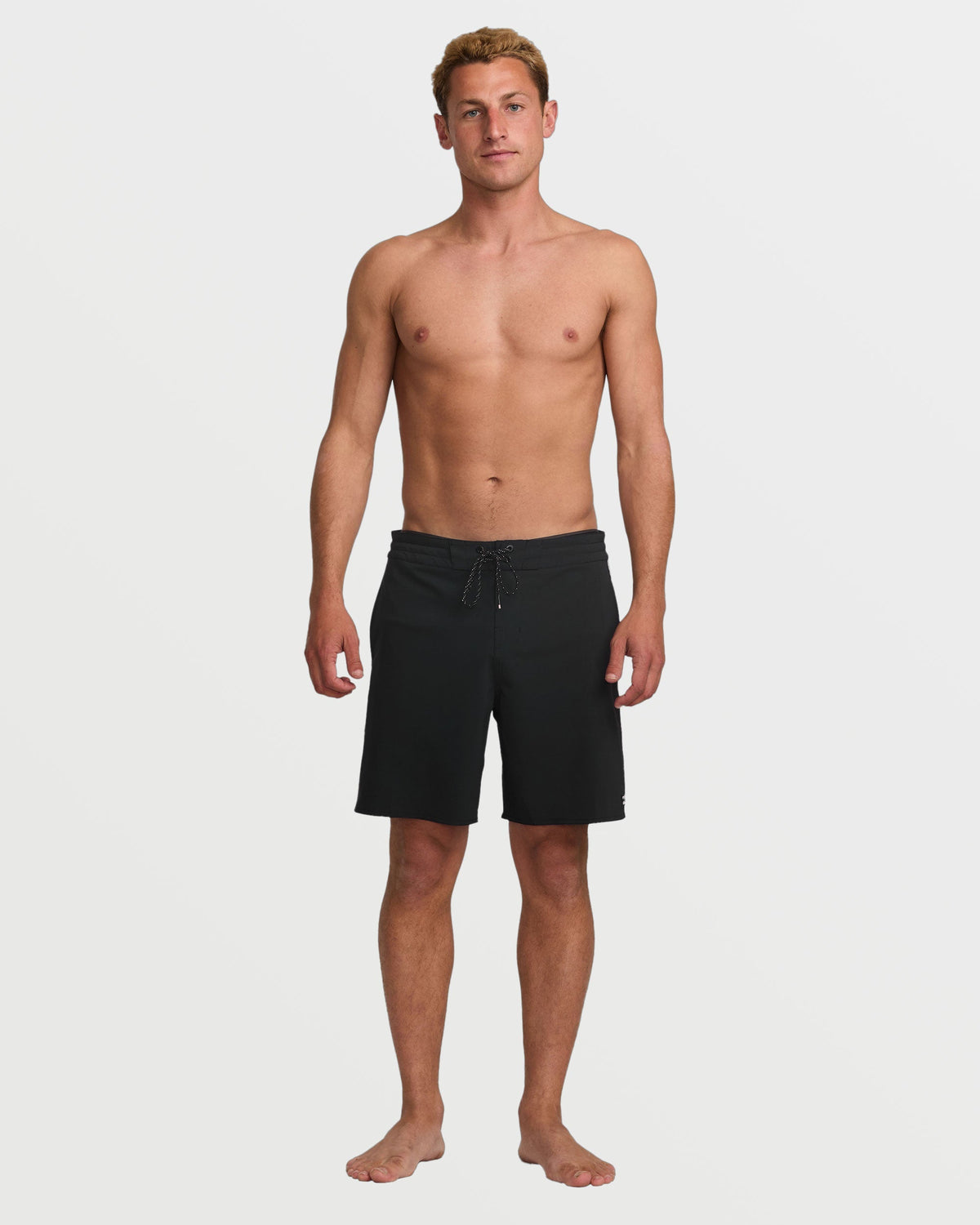 Man wearing black boardshorts with drawstring waist, knee-length cut.