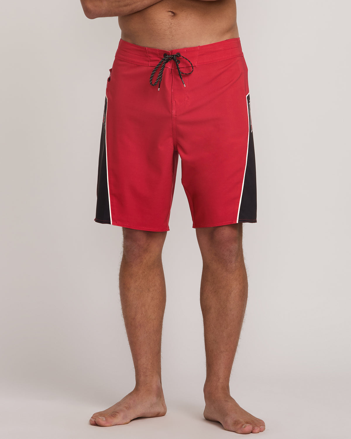 Red boardshorts with black side panels and drawstring waistband.