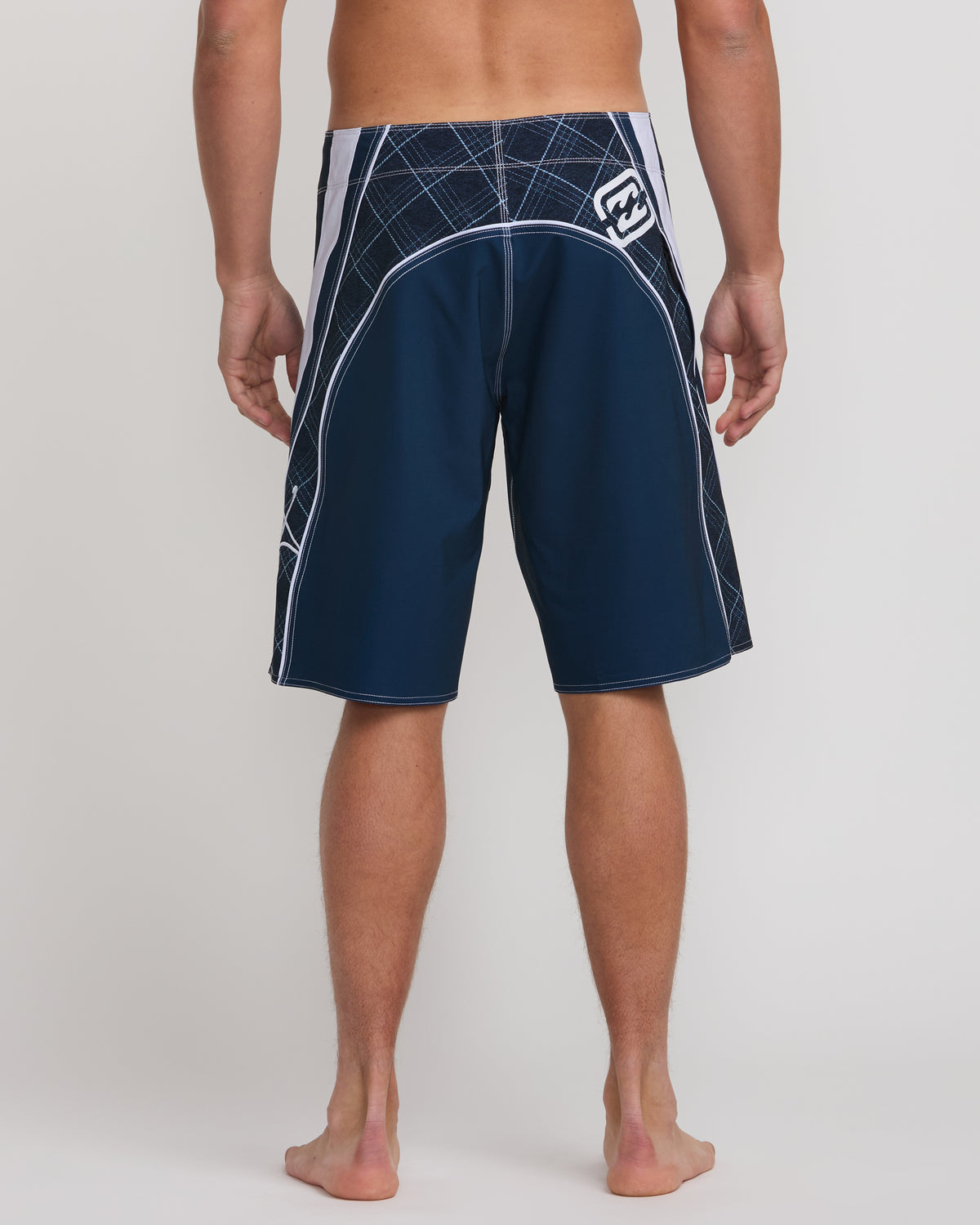 Midnight blue boardshorts with white geometric pattern on waistband and side panels, shown on male model from waist down.
