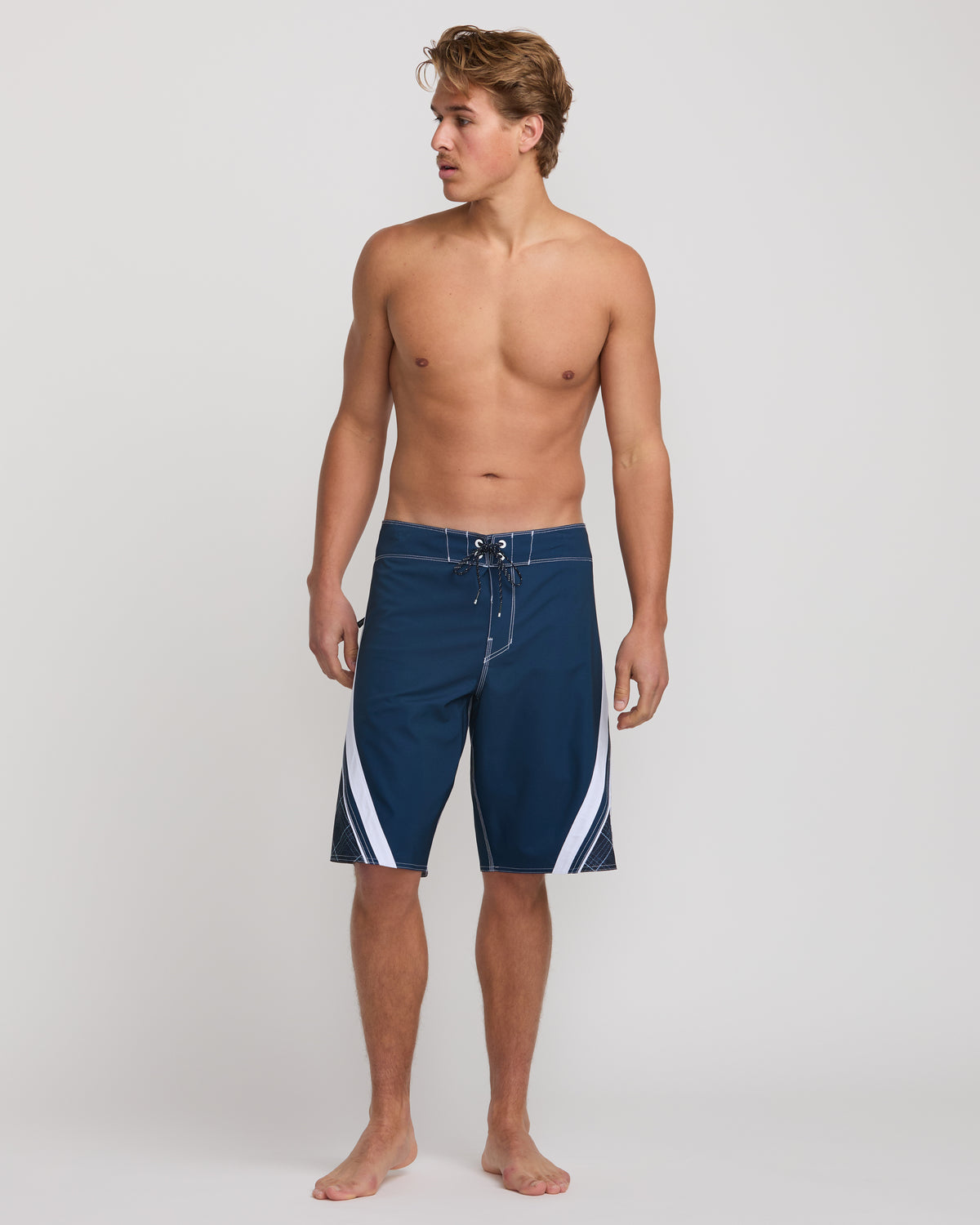 Dark blue boardshorts with white side stripes and drawstring waist on model.