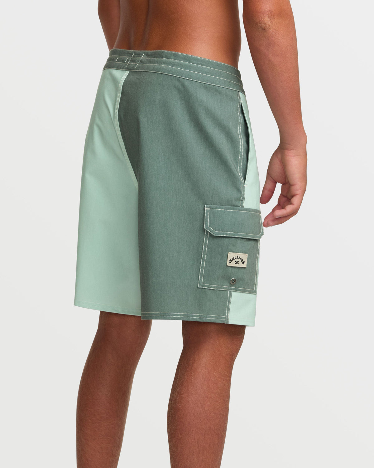 Green tea boardshorts with two-tone colorblock design, cargo pocket, and contrast stitching worn by male model.