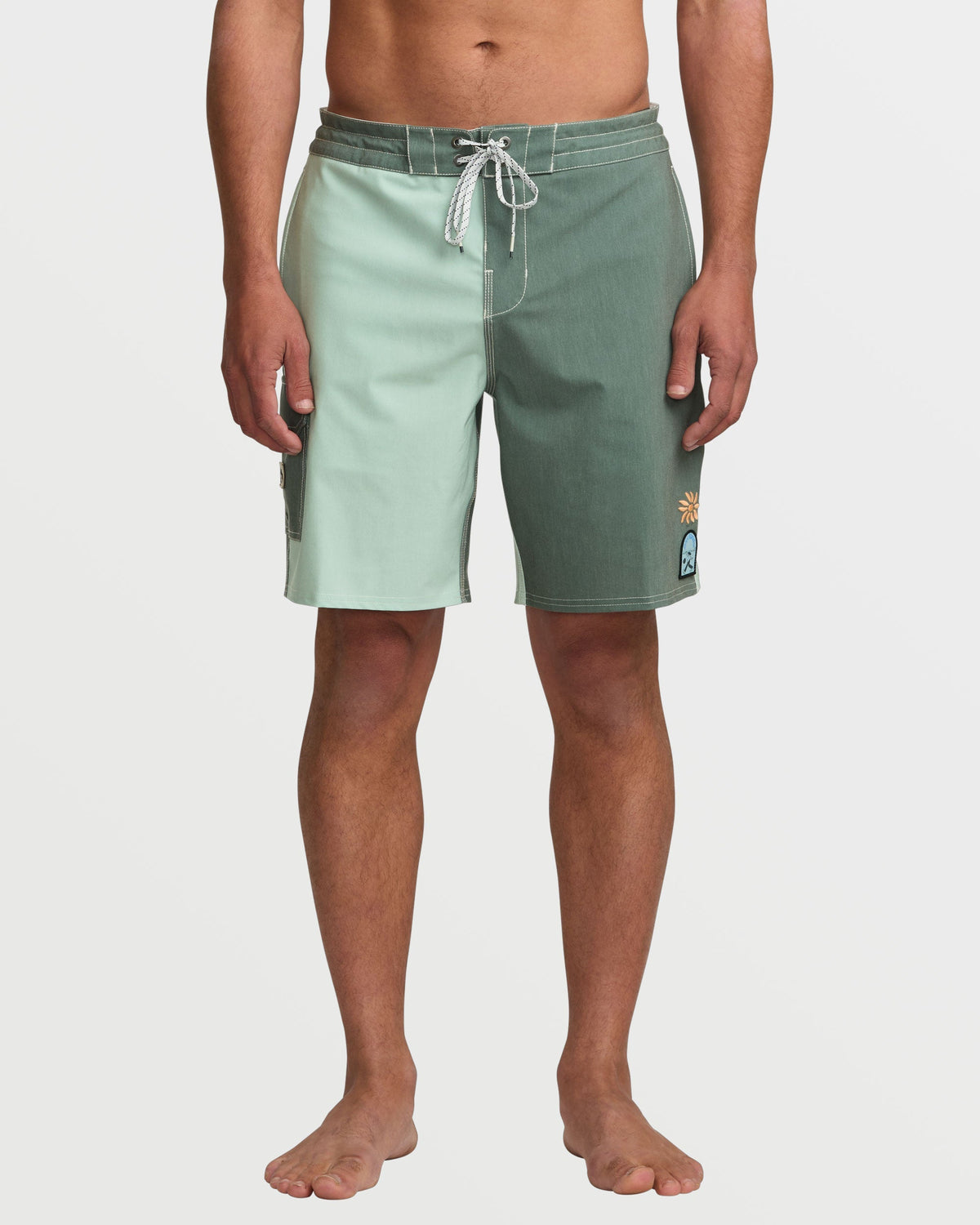 Men's green tea color-block boardshorts with drawstring waist and small patch details on leg.