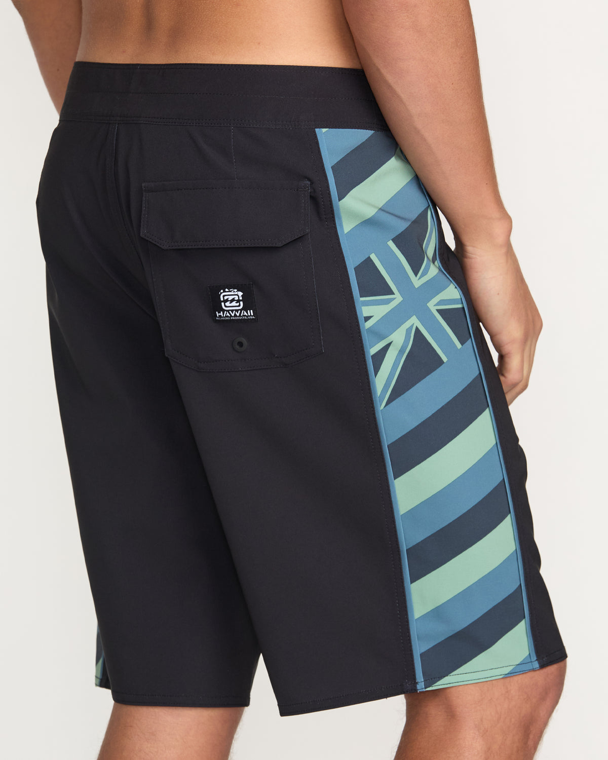 Washed black boardshorts with blue and green geometric stripe panel on side, back pocket, and brand logo patch.