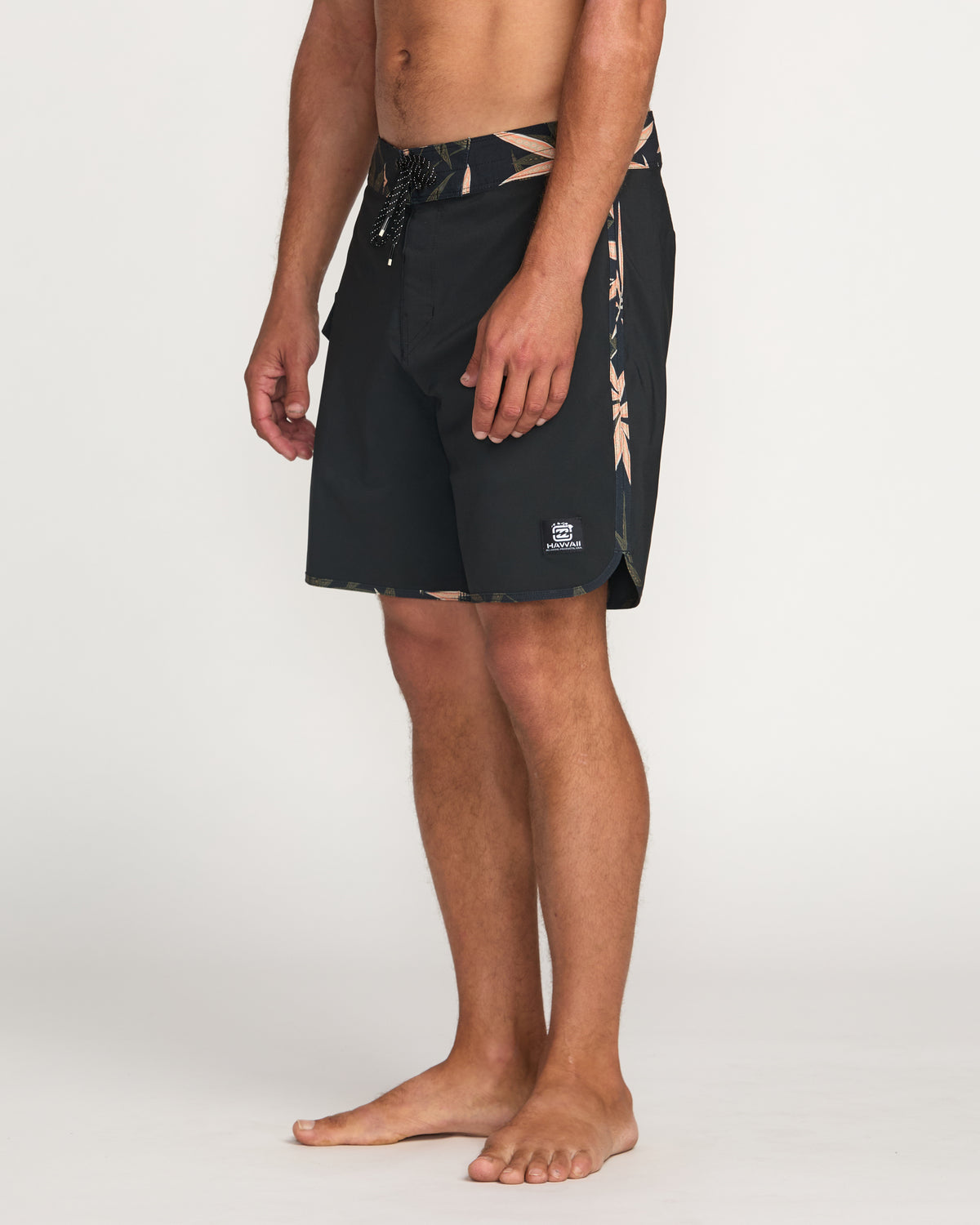 Black 18" boardshorts with tan side stripe and drawstring waistband on male model.