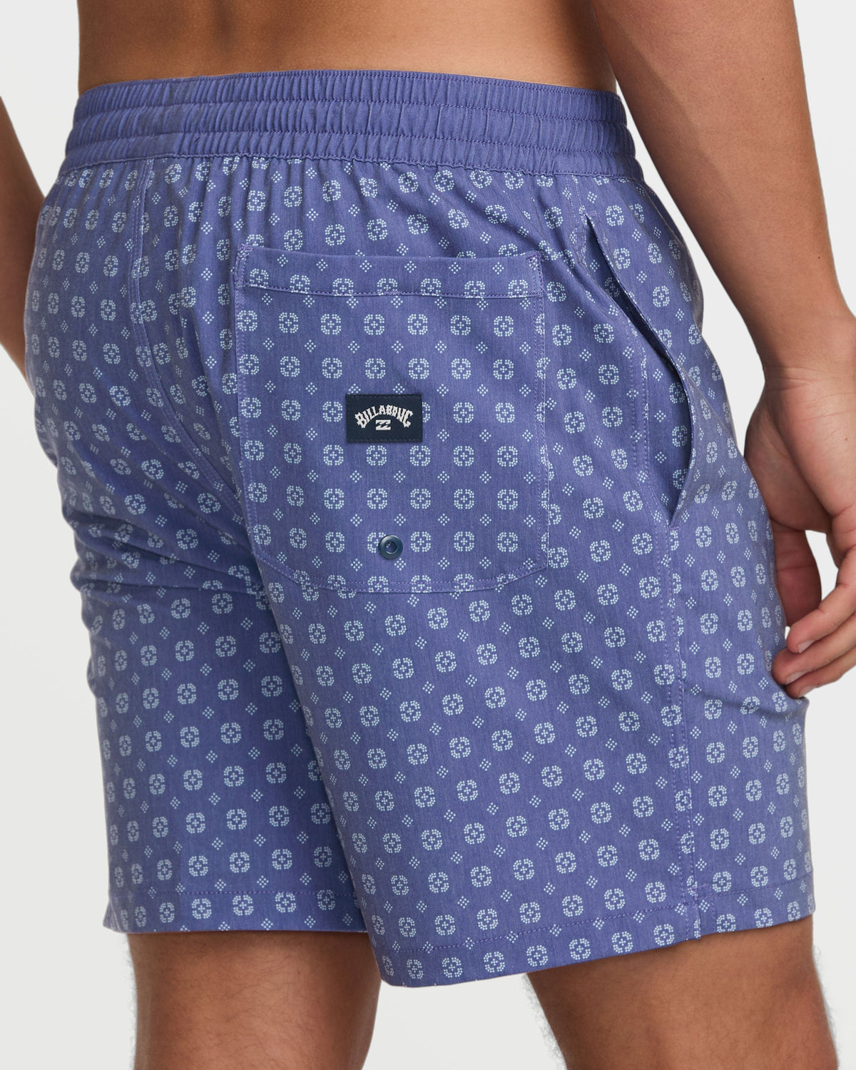 Deep blue swim trunks with small geometric print pattern, elastic waistband, and Billabong logo patch.