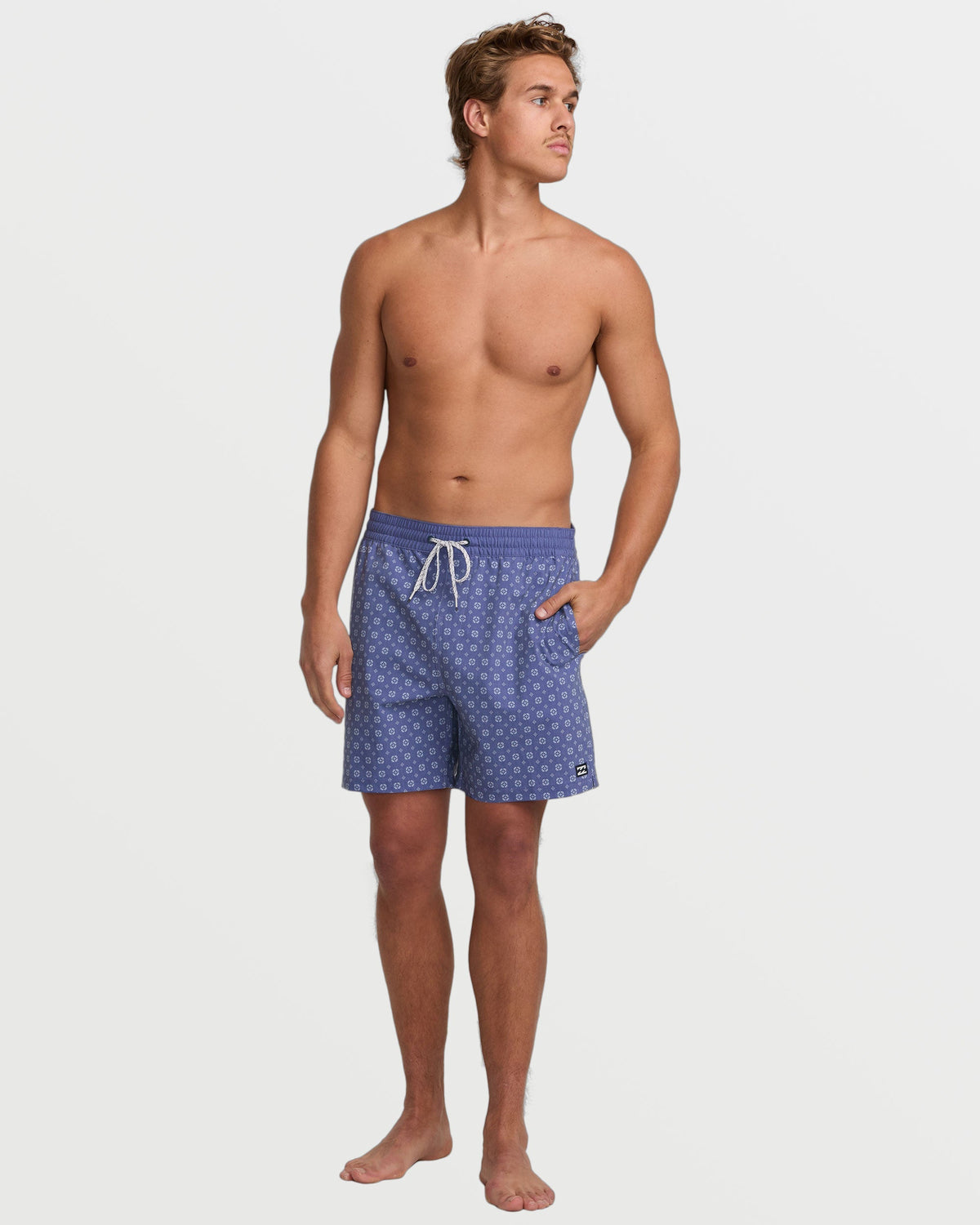 Deep blue swim trunks with small geometric pattern and white drawstring on model.