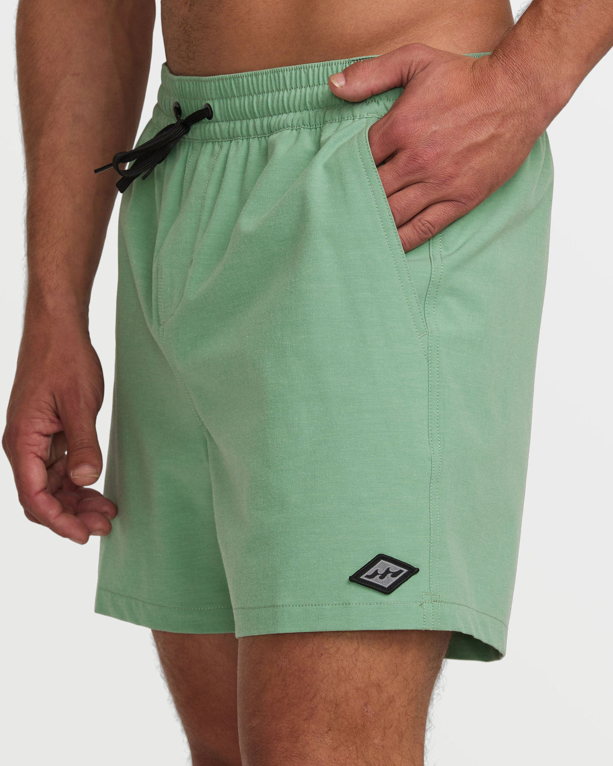 Moss green 16" swim trunks with black drawstring, elastic waistband, side pockets, and brand logo patch.