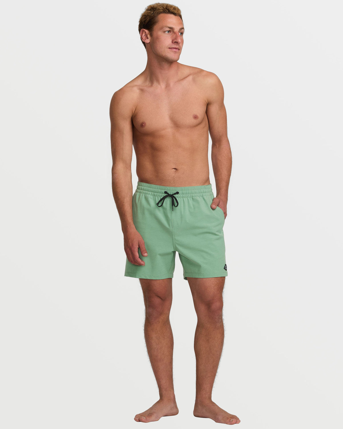 Moss green swim trunks with drawstring waist and side pockets on male model.