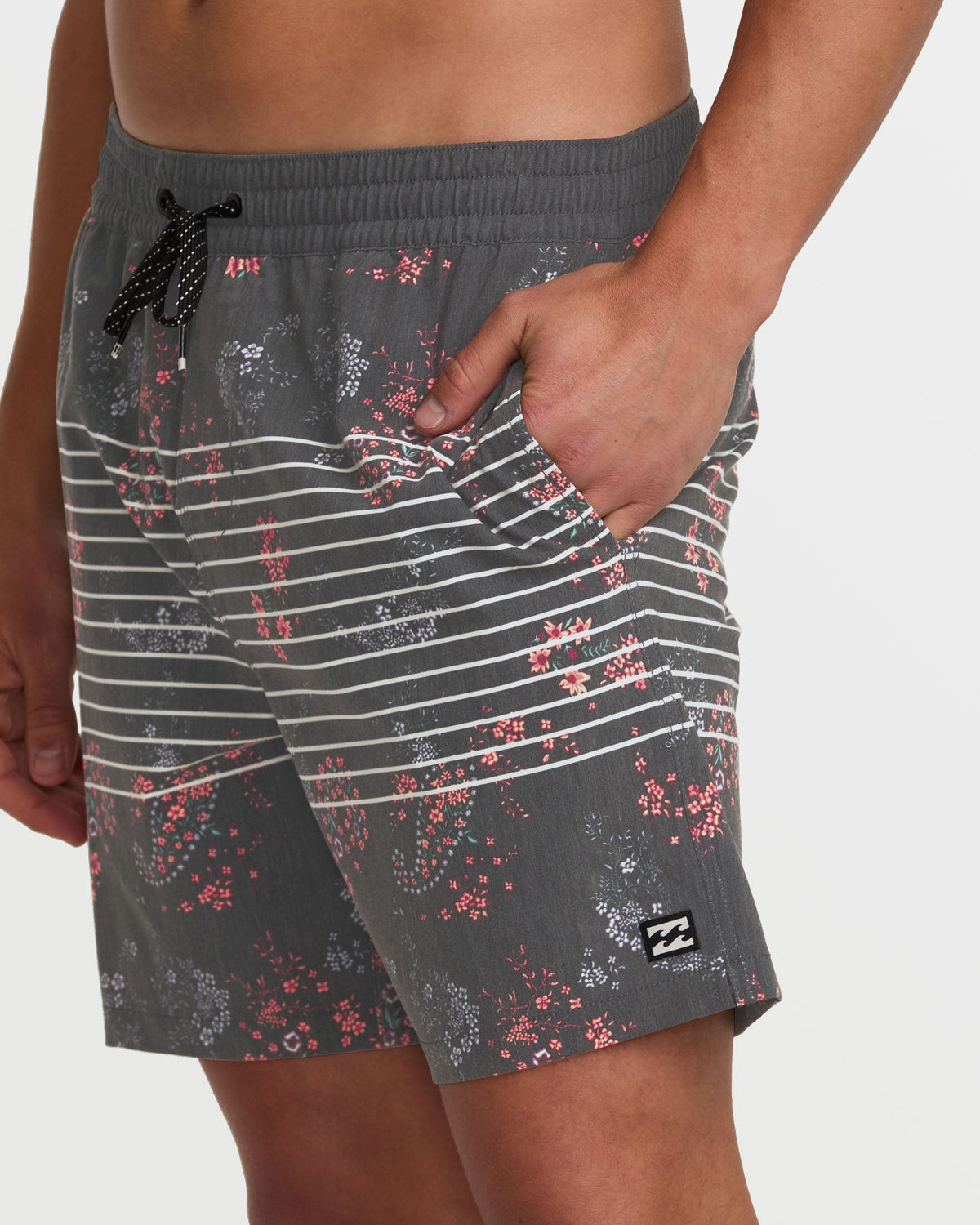 Dark gray swim trunks with horizontal white stripes and red floral print throughout, featuring a black drawstring.