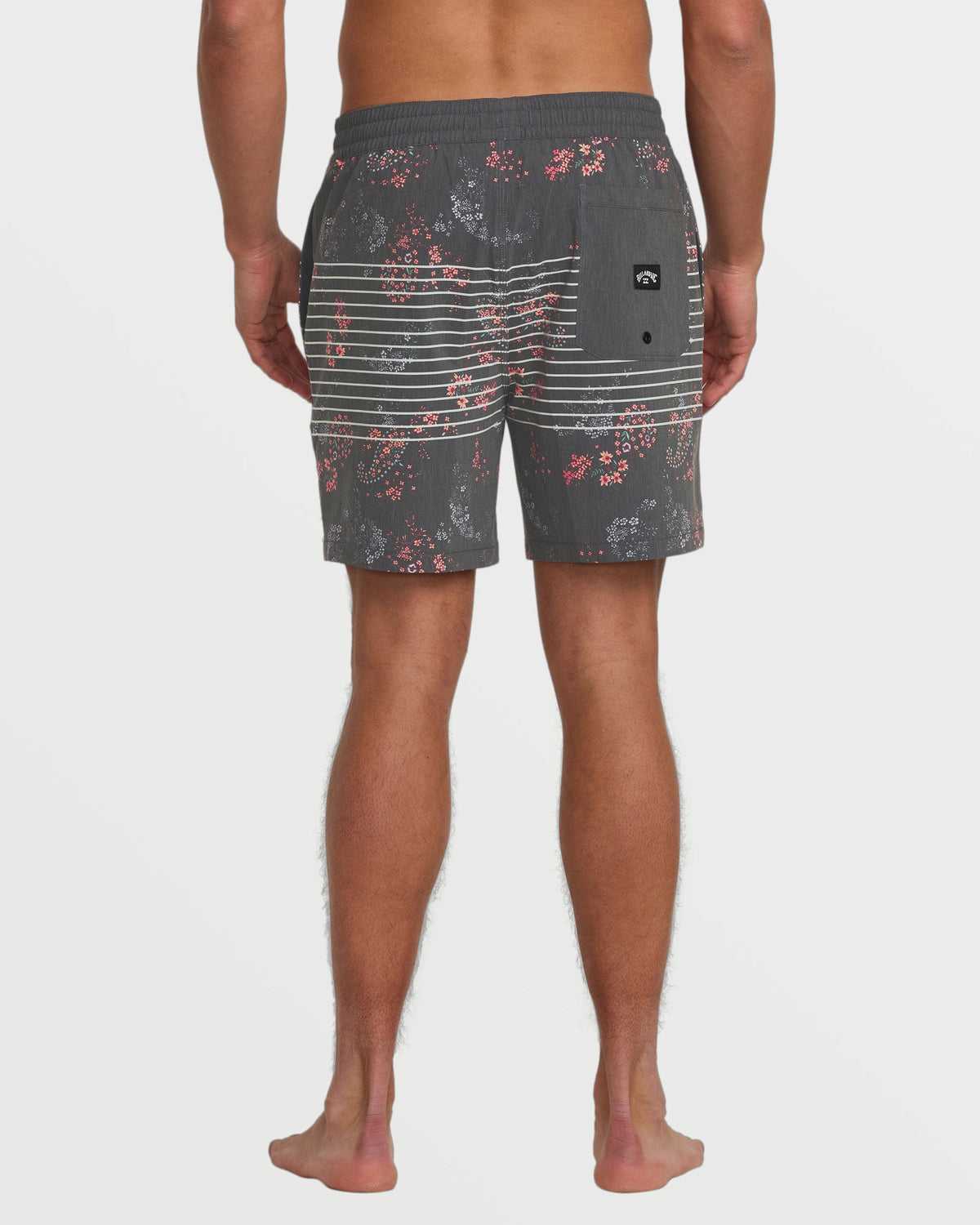 Man wearing gray swim trunks with horizontal stripes and red speckled pattern, viewed from back.
