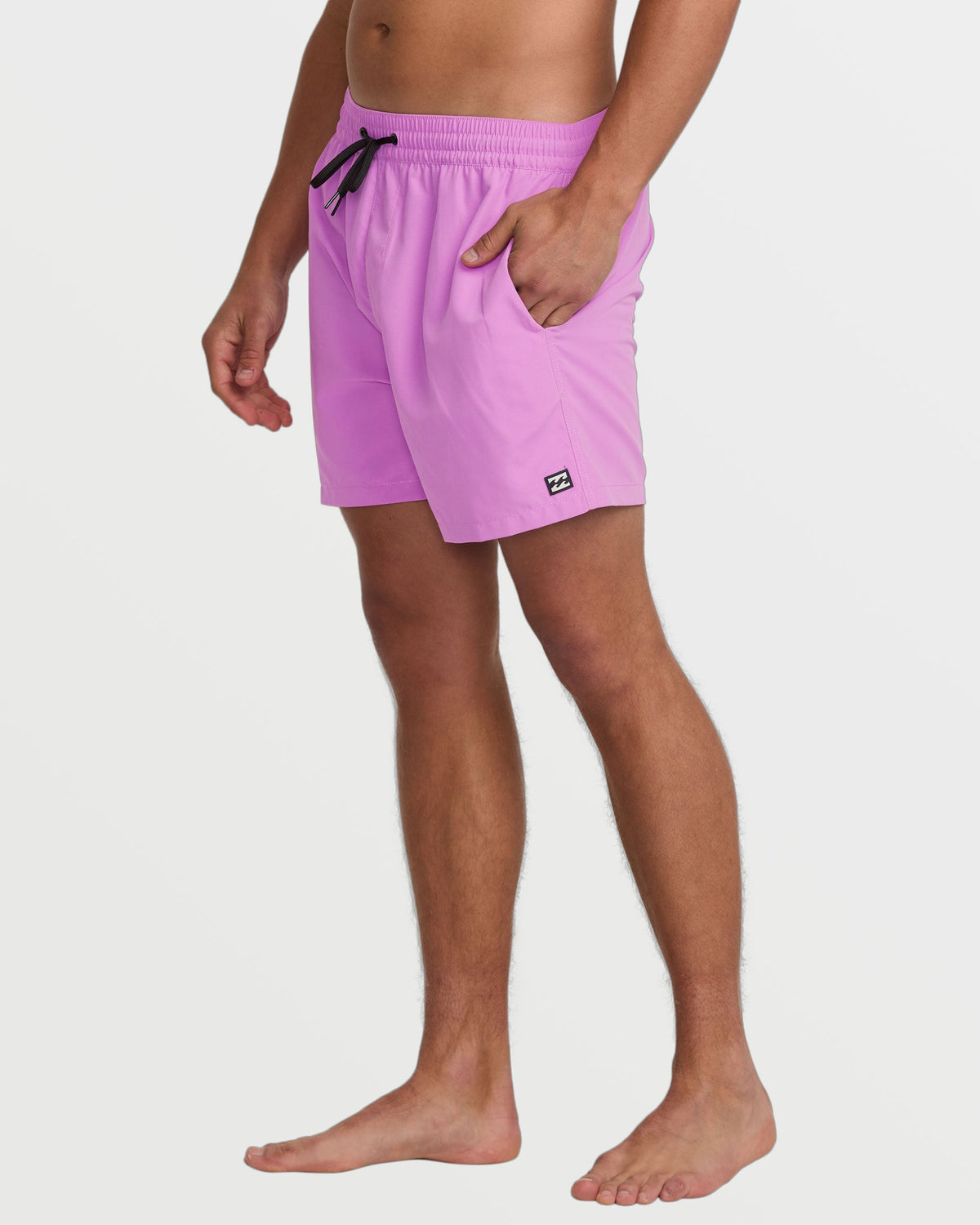 Fuschia swim trunks with elastic waistband, drawstring, front pockets, and small logo patch on leg.