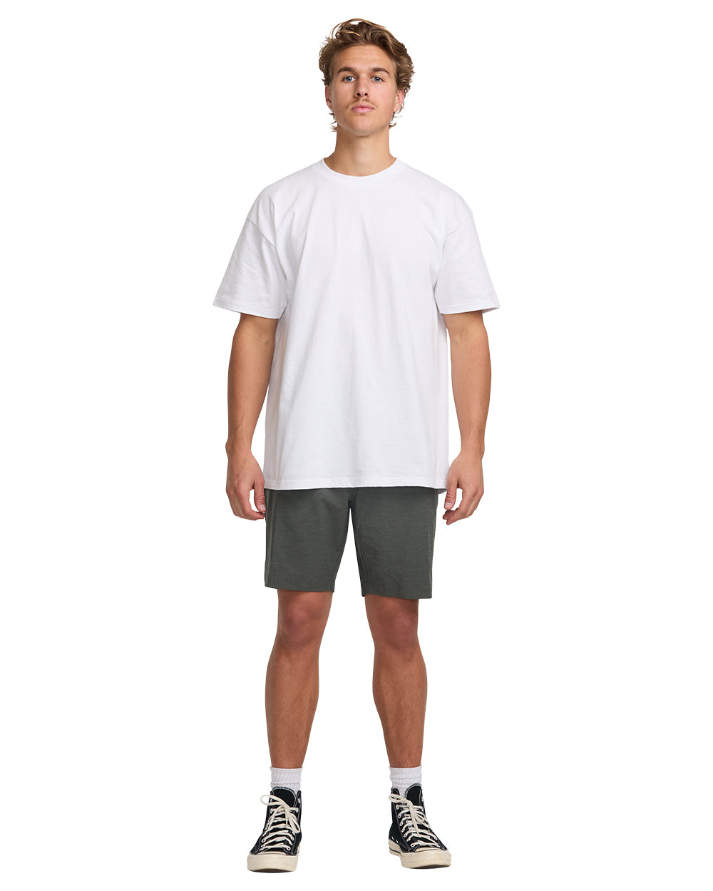 Man wearing white t-shirt and asphalt gray hybrid shorts with black and white sneakers.