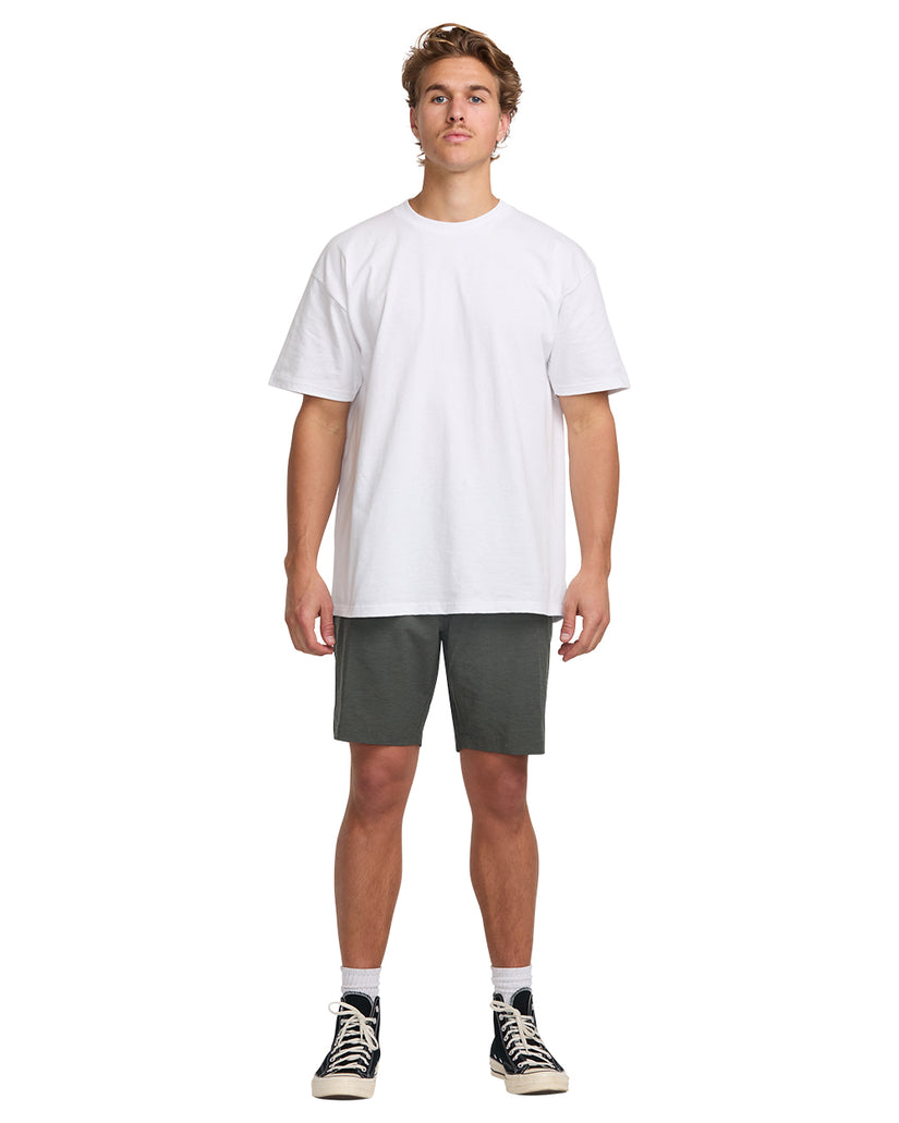 Man wearing white t-shirt and asphalt gray hybrid shorts with black and white sneakers.
