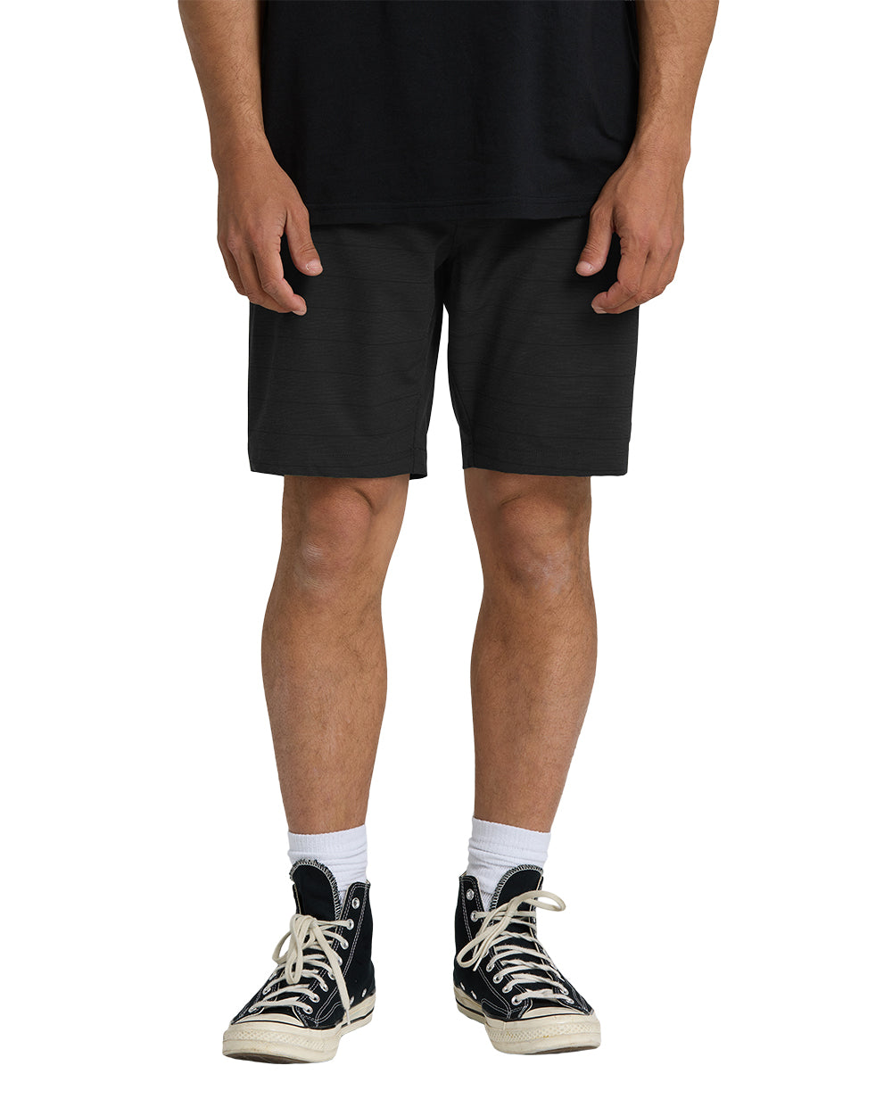 Black hybrid shorts with textured fabric worn with white socks and black high-top sneakers.