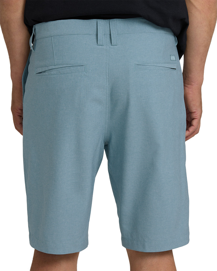 Light blue textured hybrid shorts with back welt pockets and drawstring waistband, worn on model.