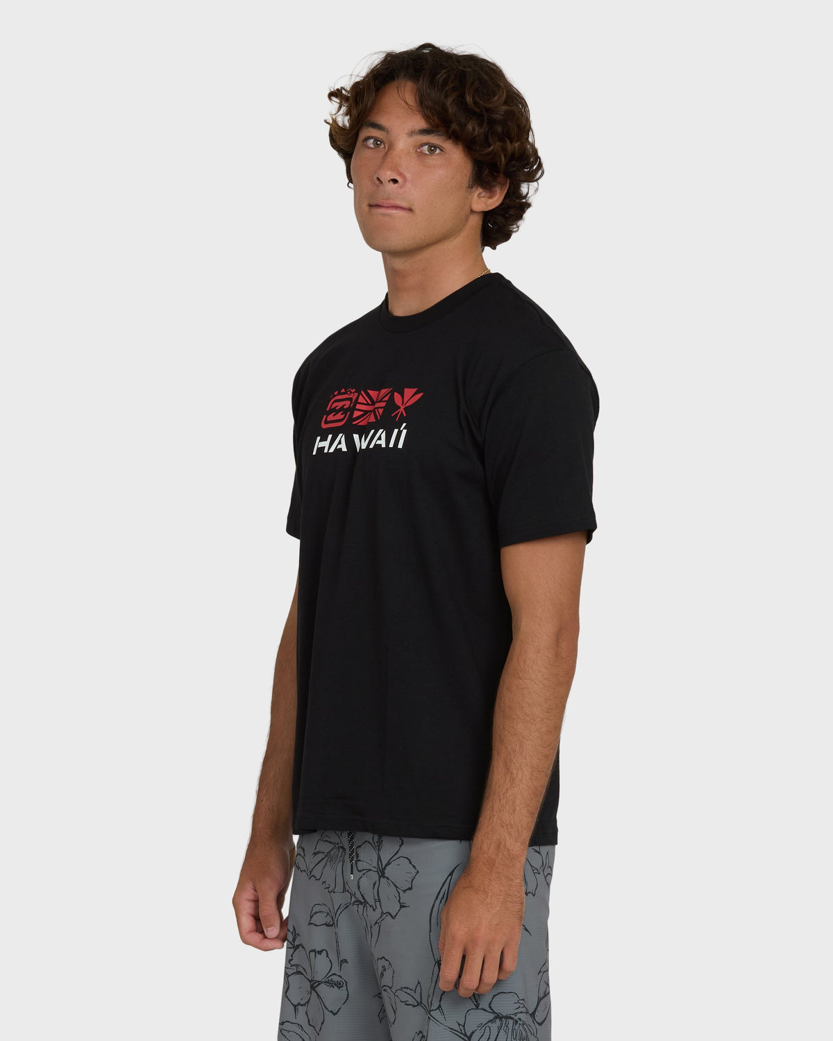 Black short-sleeve t-shirt with red and white "Hawaii" text and geometric design on chest.
