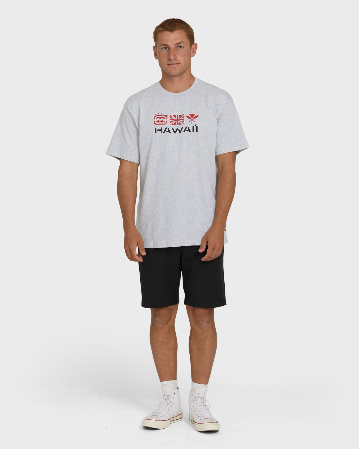 Heather gray short-sleeve t-shirt with "Hawaii" text and decorative icons on chest, worn with black shorts.