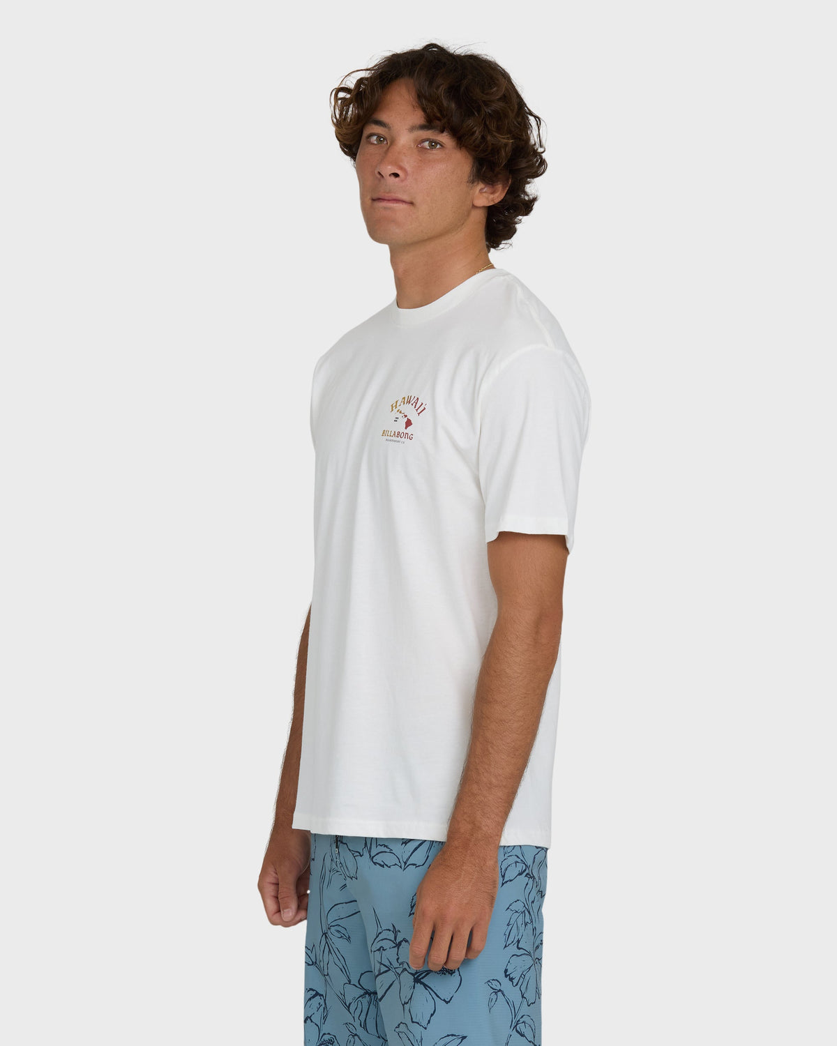 Off-white short sleeve t-shirt with small chest graphic worn with blue patterned shorts.