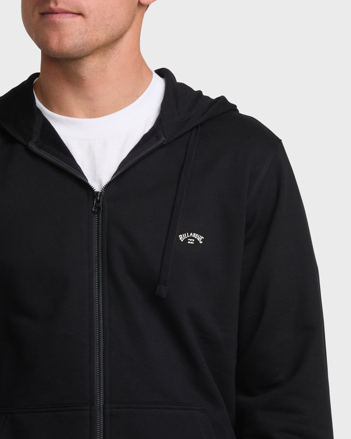 Black zip-up hoodie sweatshirt with white text logo on chest, worn over white t-shirt.