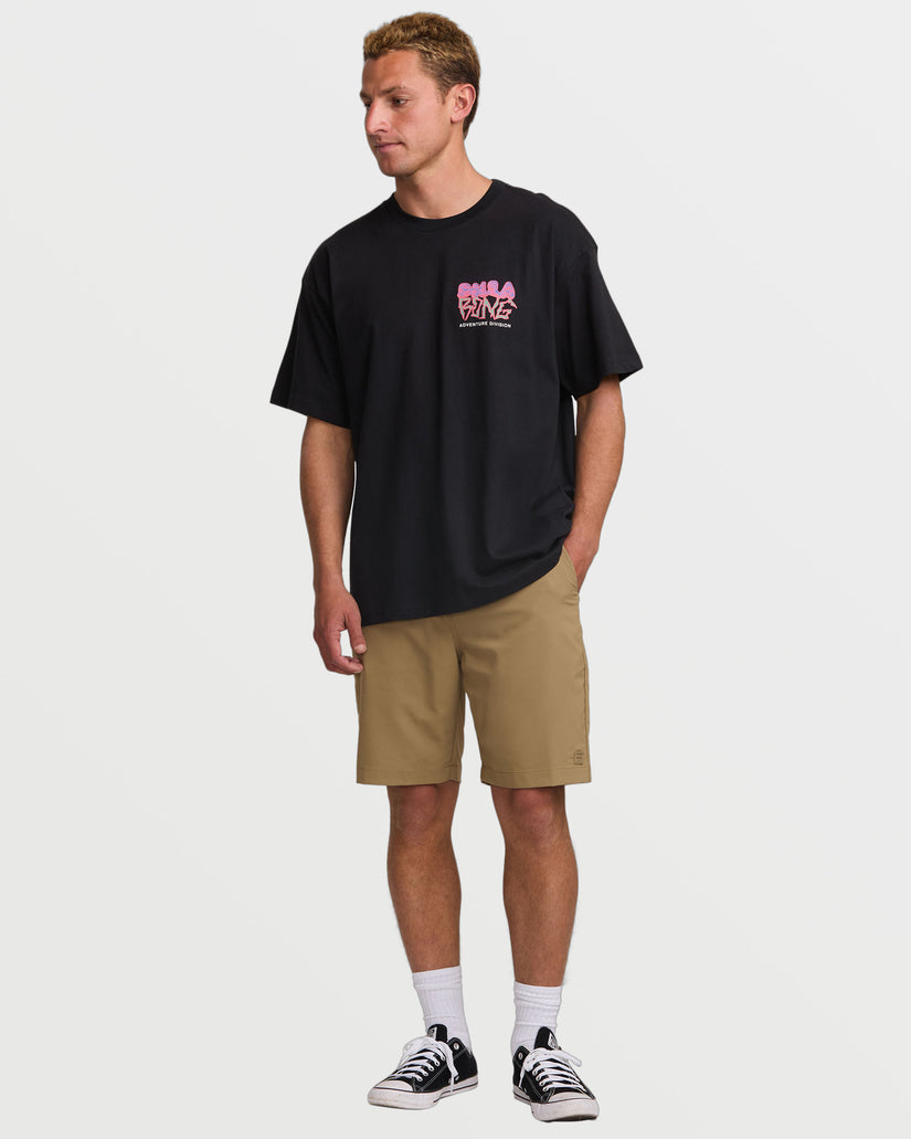 Black short sleeve tee with pink graphic print on chest, worn with tan shorts.