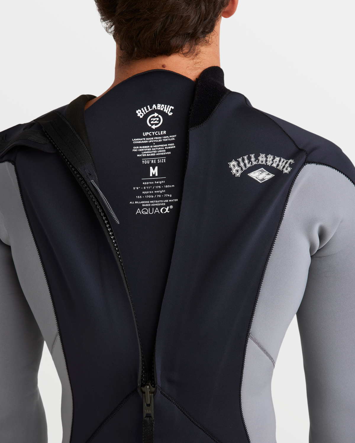 Black and gray wetsuit with back zip closure and Billabong branding on chest and back.