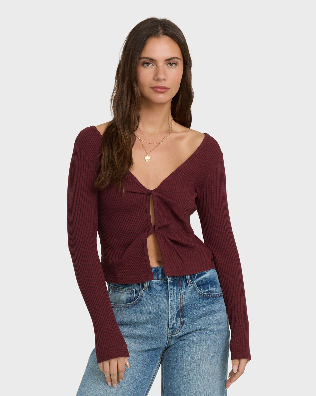 Burgundy ribbed long-sleeve knit top with twisted front detail and V-neckline.
