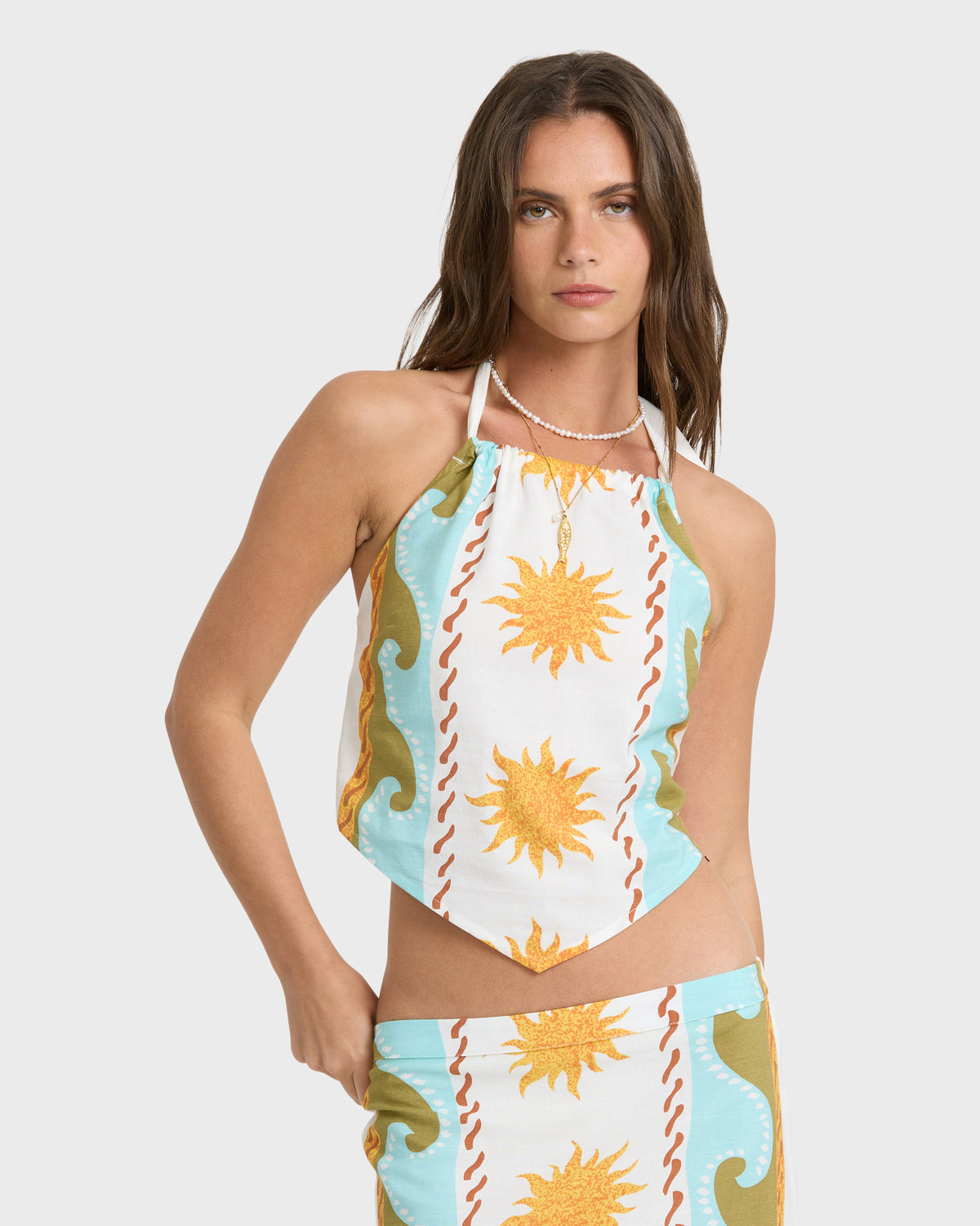 Woven halter top in cream with yellow suns, blue waves, and red wavy stripes, paired with matching bottom.