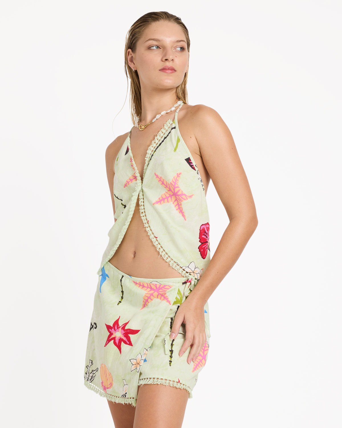 Lime-green woven tank top with colorful embroidered flowers and crochet trim, worn with matching skirt.