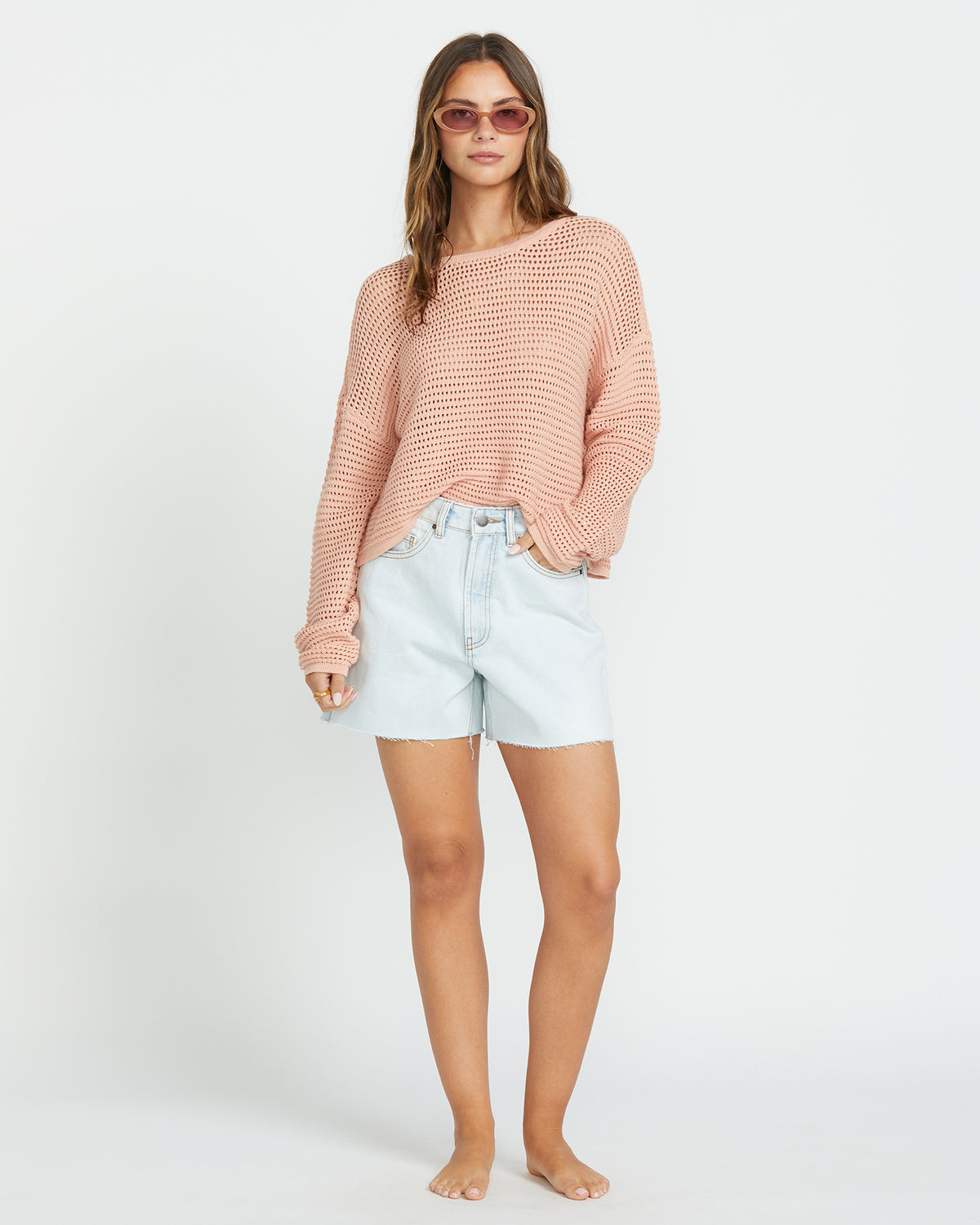 Faded rose knit sweater with textured pattern worn with light blue denim shorts.