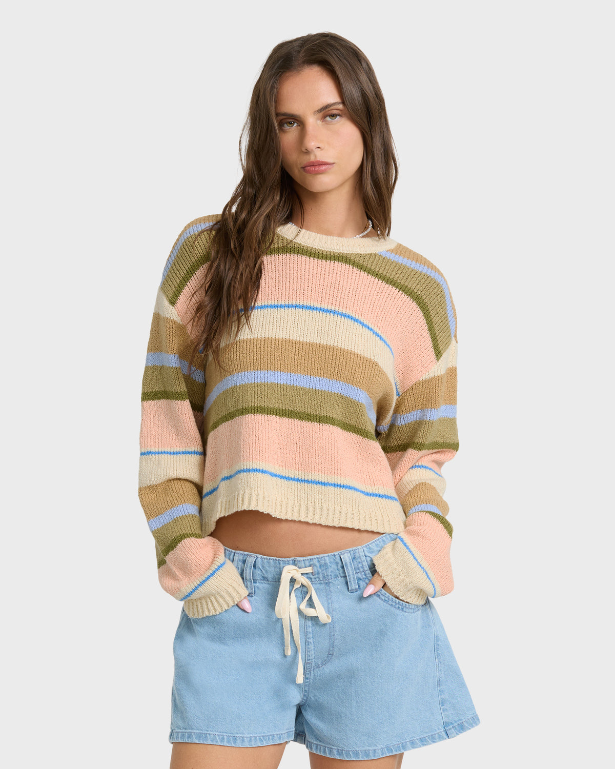 Light peach sweater with horizontal stripes in olive, tan, and blue, cropped fit, crew neckline.