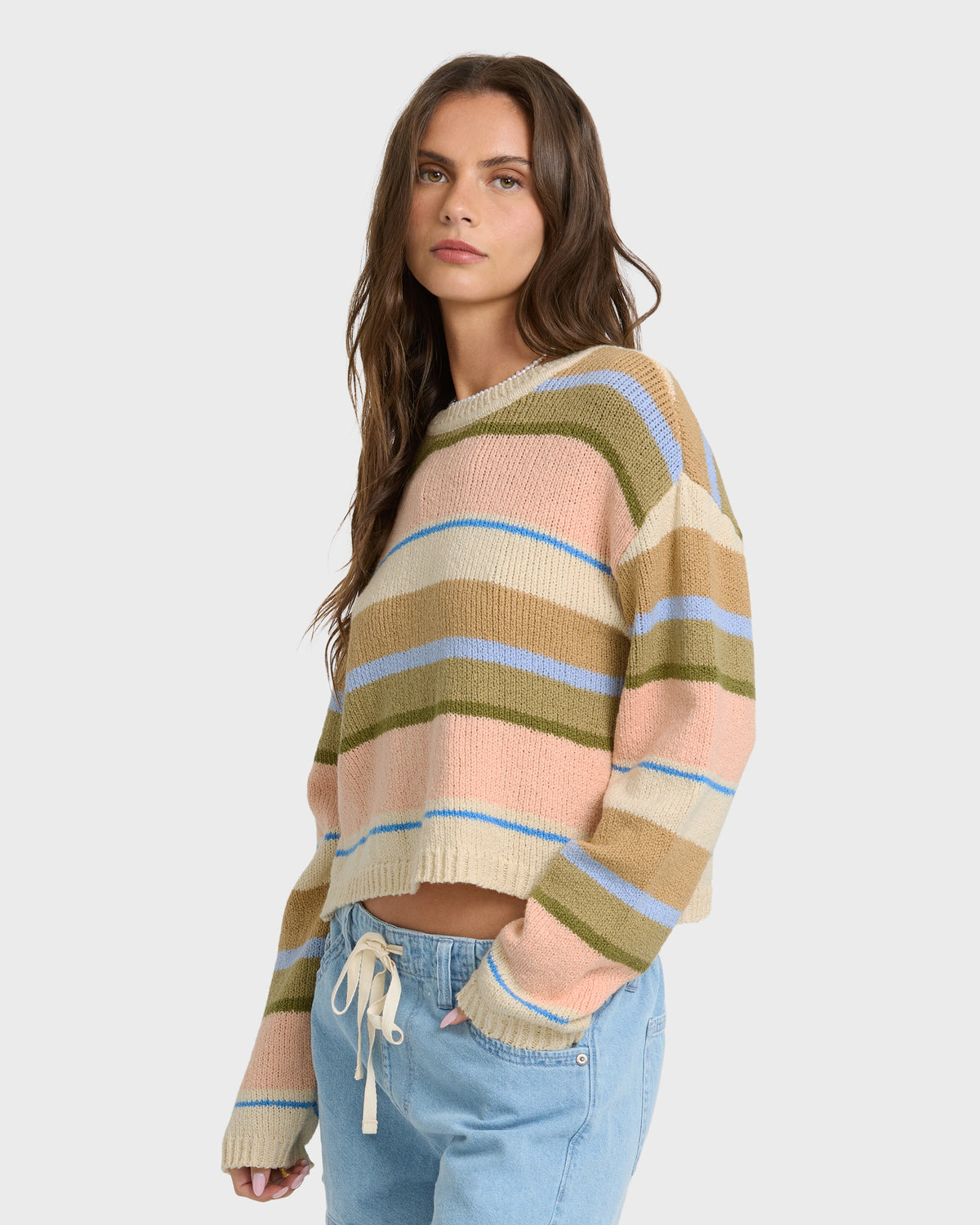 Light peach knit sweater with horizontal stripes in cream, blue, olive, and tan throughout.