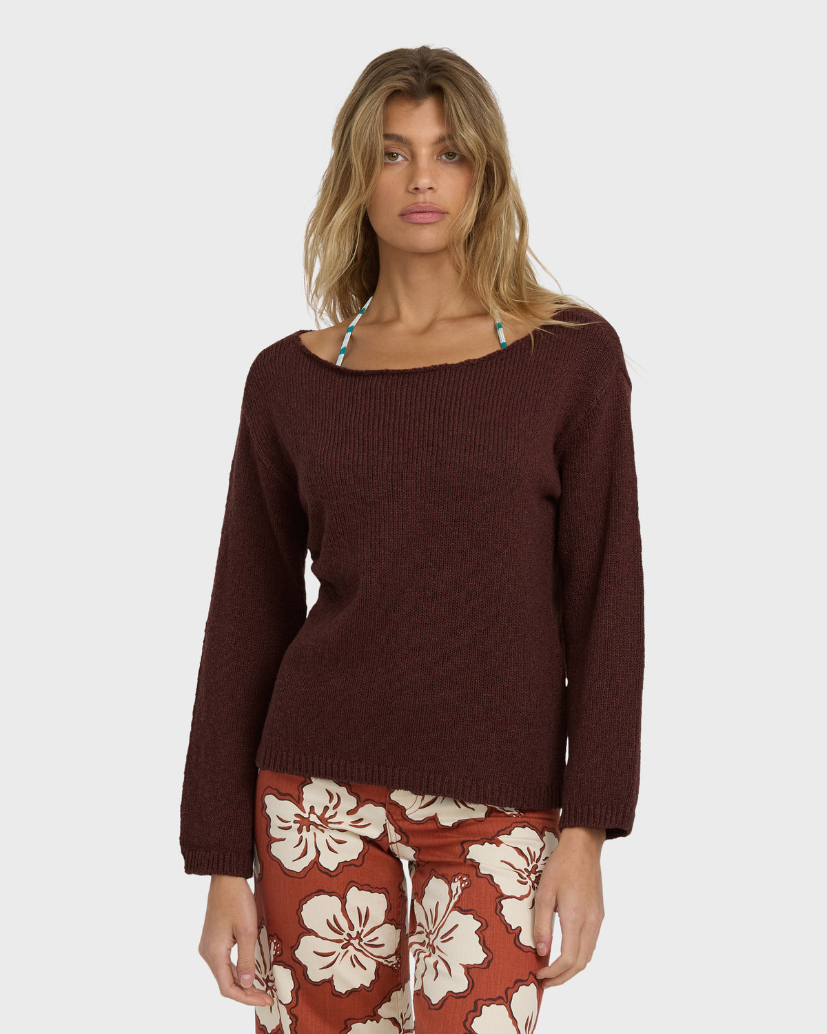 Teak ribbed sweater with crew neckline and long sleeves worn with floral patterned pants.