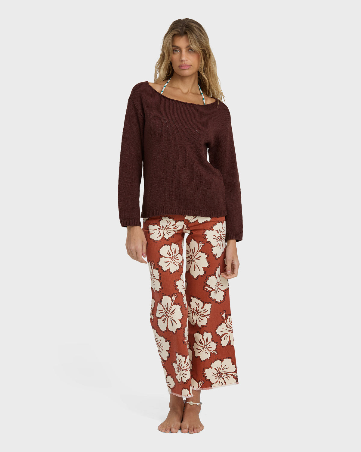 Teak ribbed sweater with long sleeves and wide neckline worn with floral print pants.