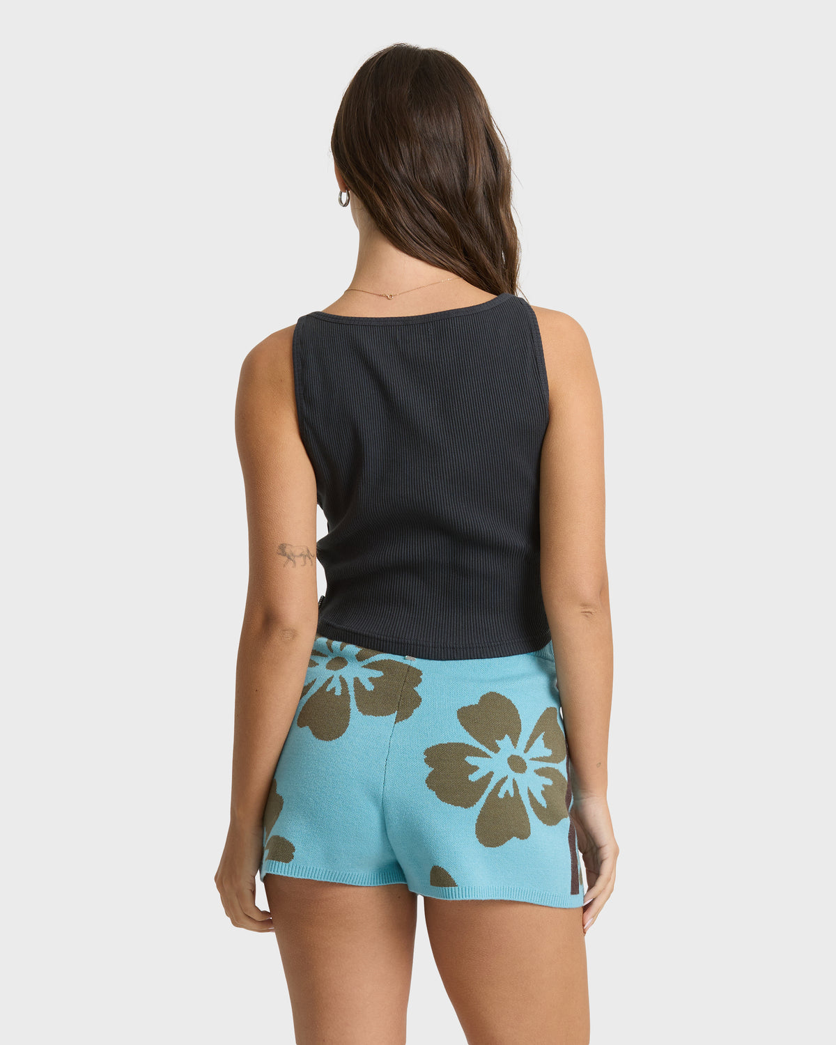 Light blue shorts with brown floral pattern, worn with black sleeveless ribbed top.