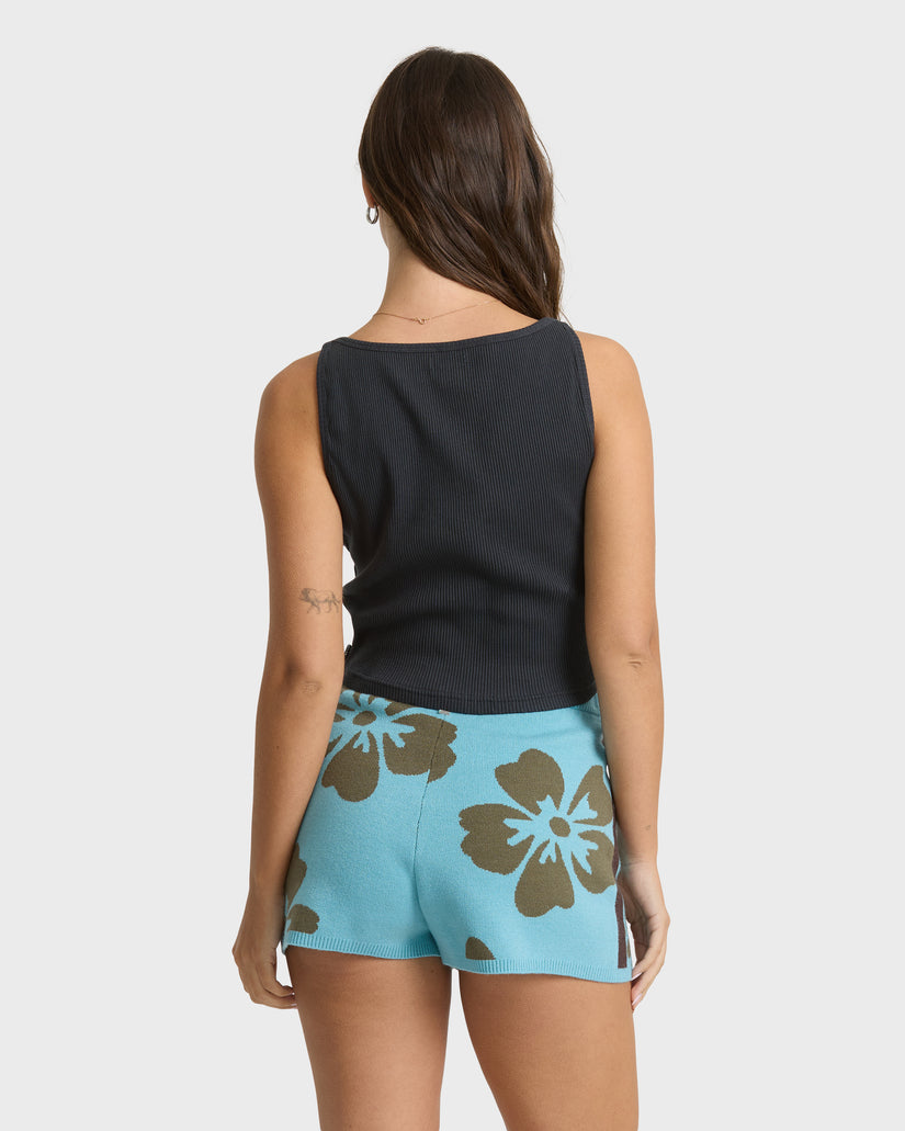 Light blue shorts with brown floral pattern, worn with black sleeveless ribbed top.