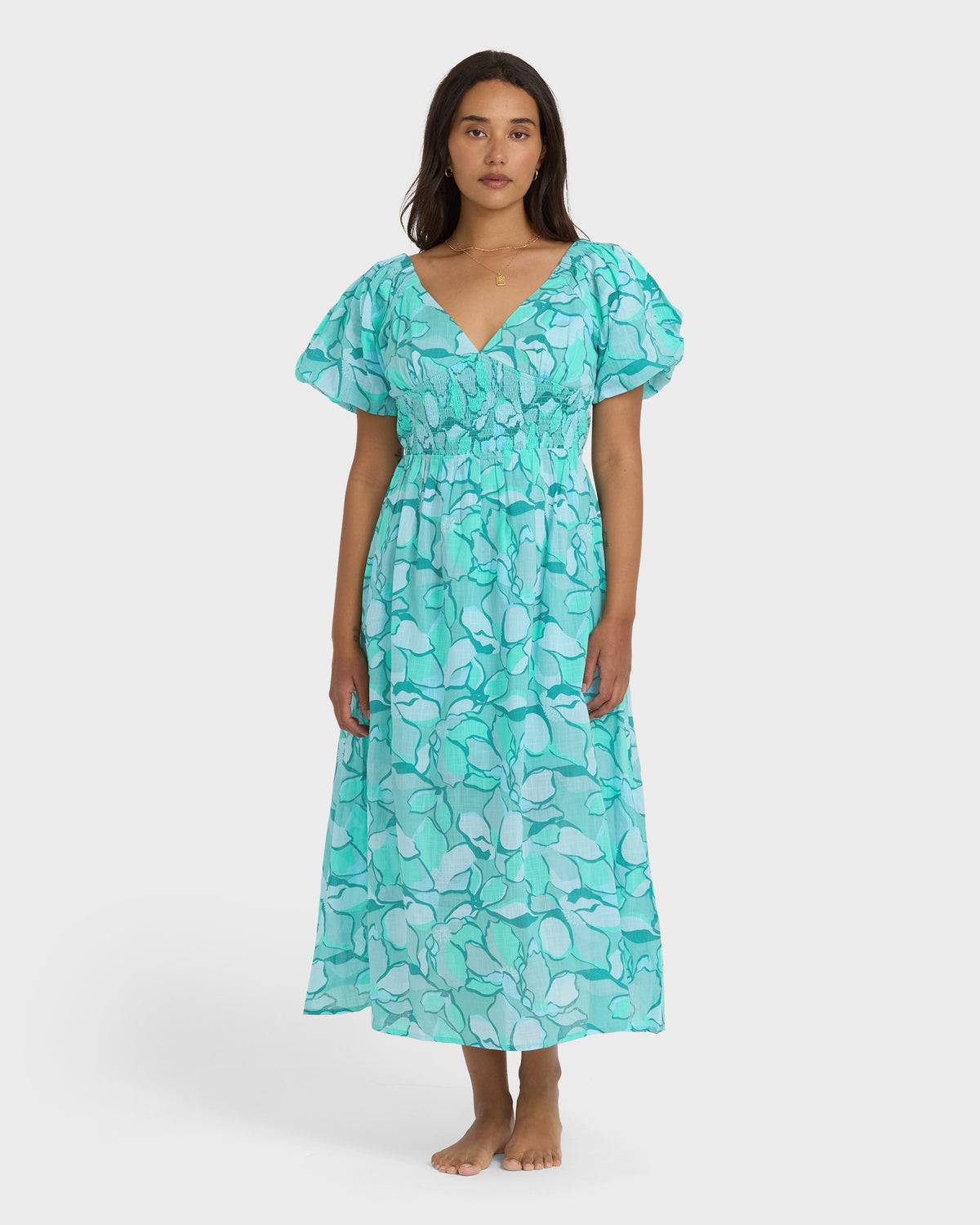 Turquoise midi dress with abstract bird print, puffed short sleeves, and V-neckline on model.