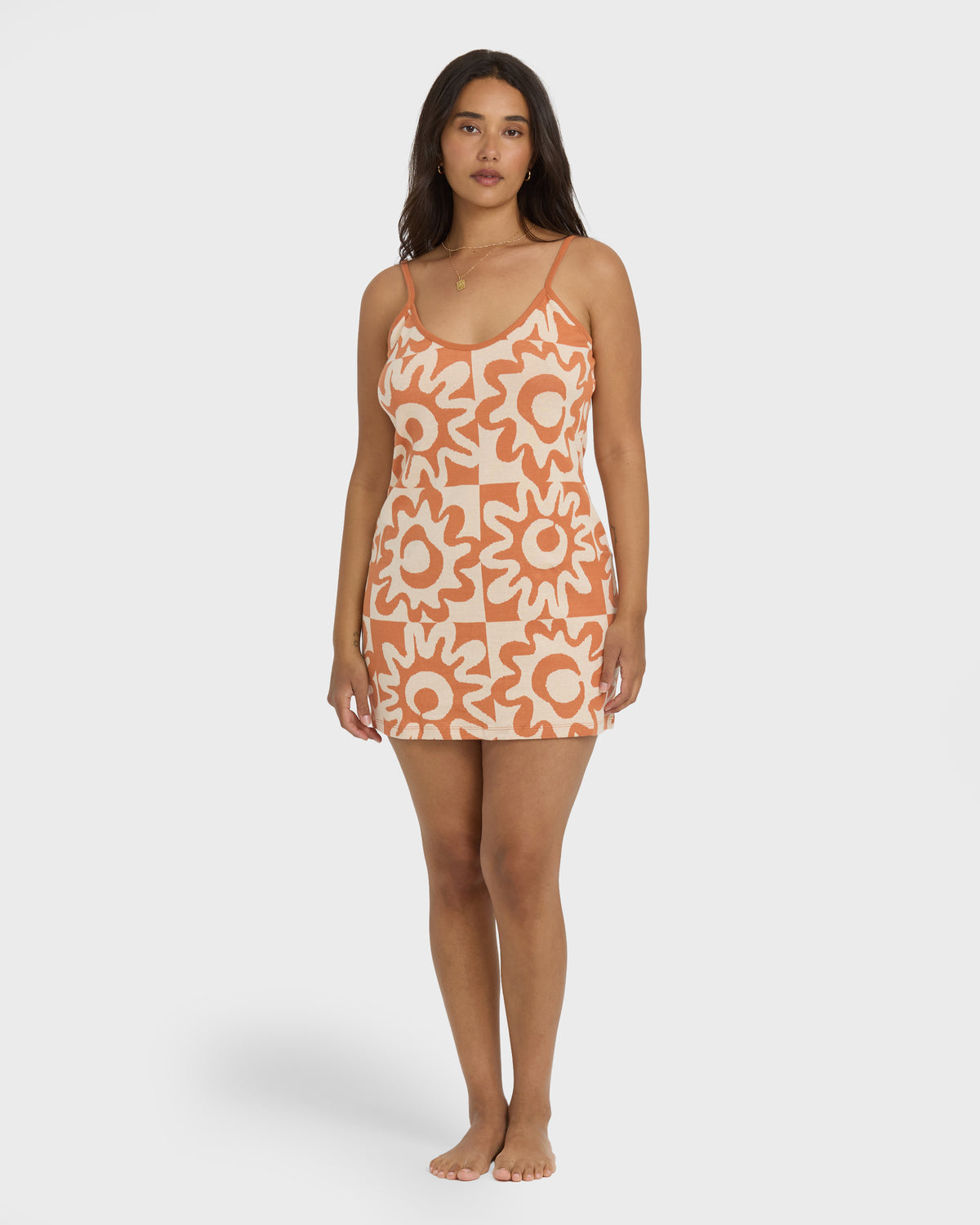 Sunburnt knit mini dress with geometric flower pattern in orange and cream, thin straps and scoop neckline.