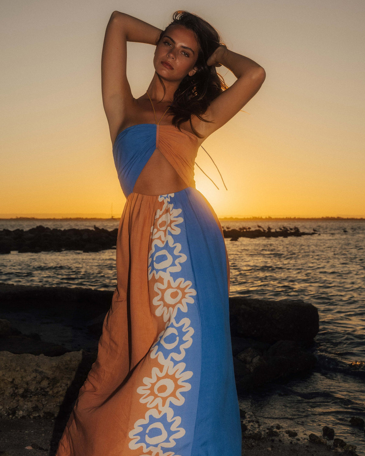 Sleeveless color-block dress in orange and blue with white daisy print panel on skirt.
