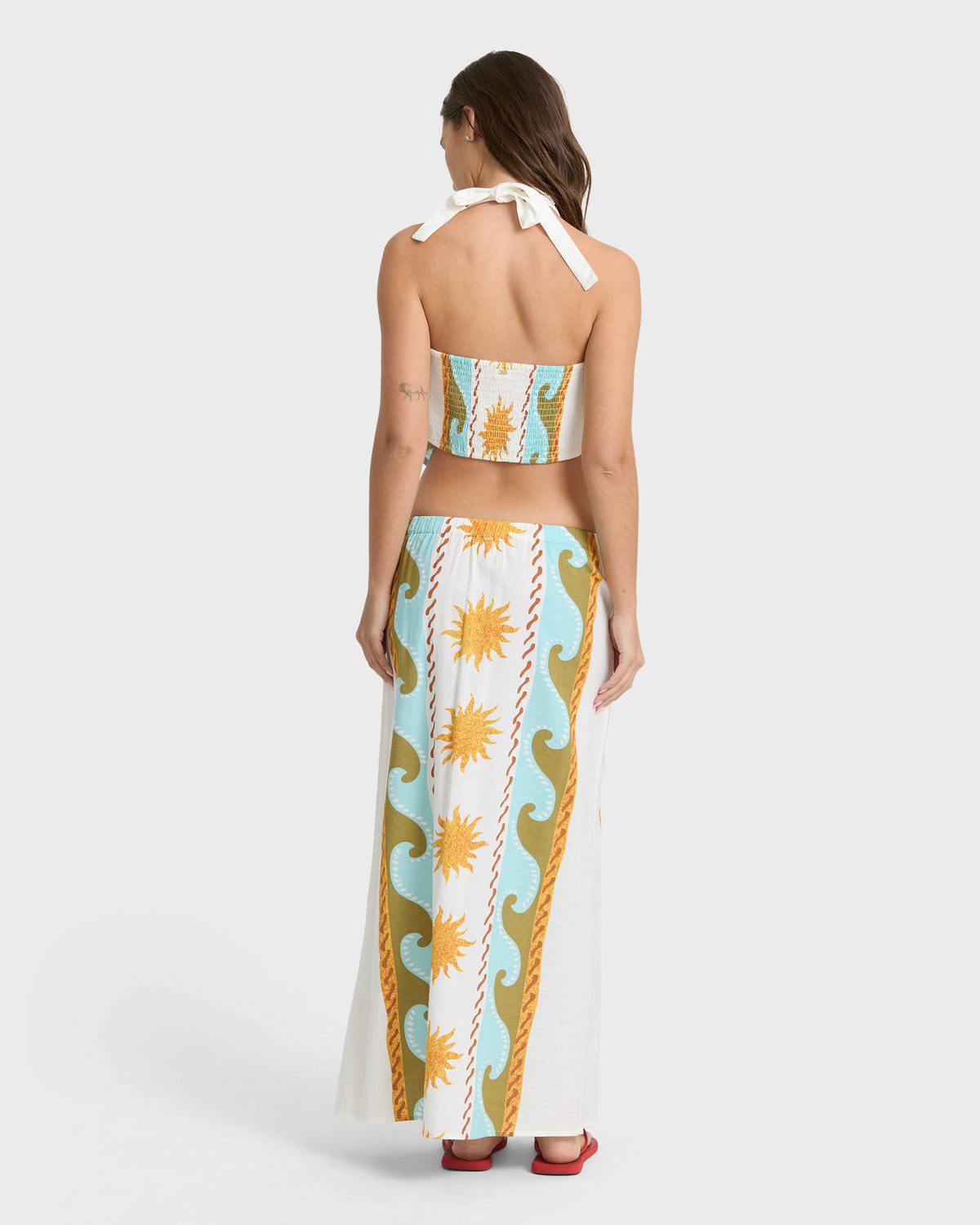 Midi skirt with sun and wave print in cream, blue, and gold tones, featuring a high waist and ankle-length cut.