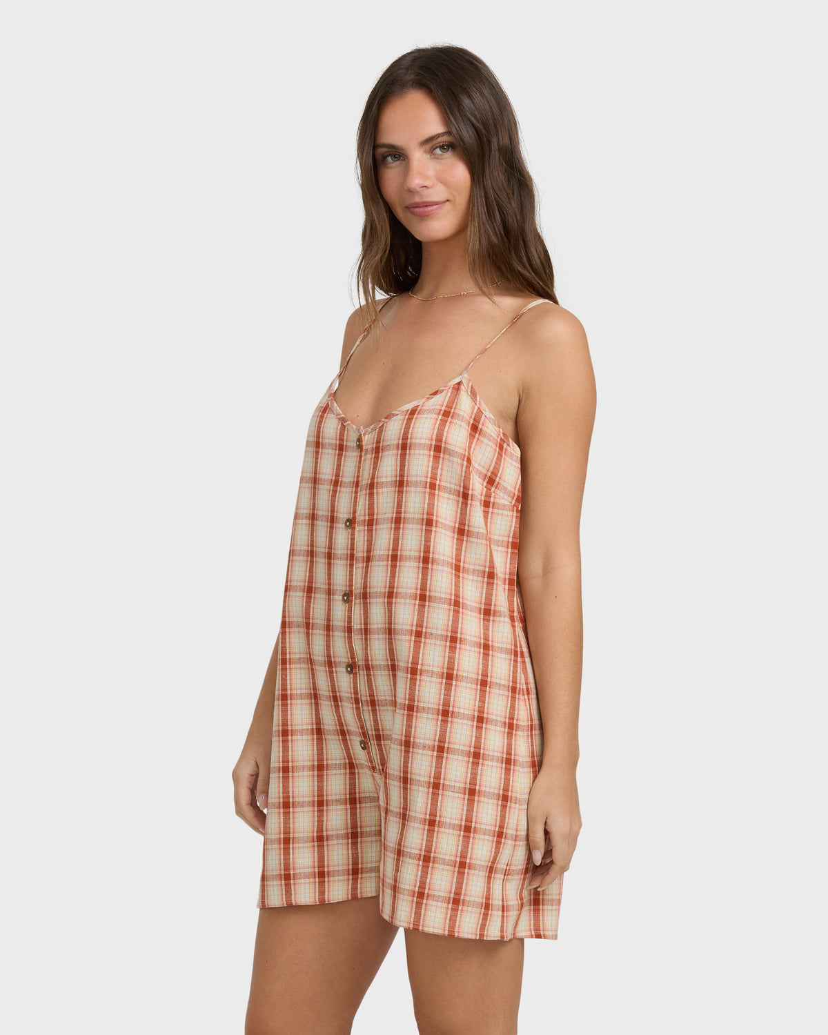 Red and white plaid sleeveless romper with button front and adjustable straps on model.