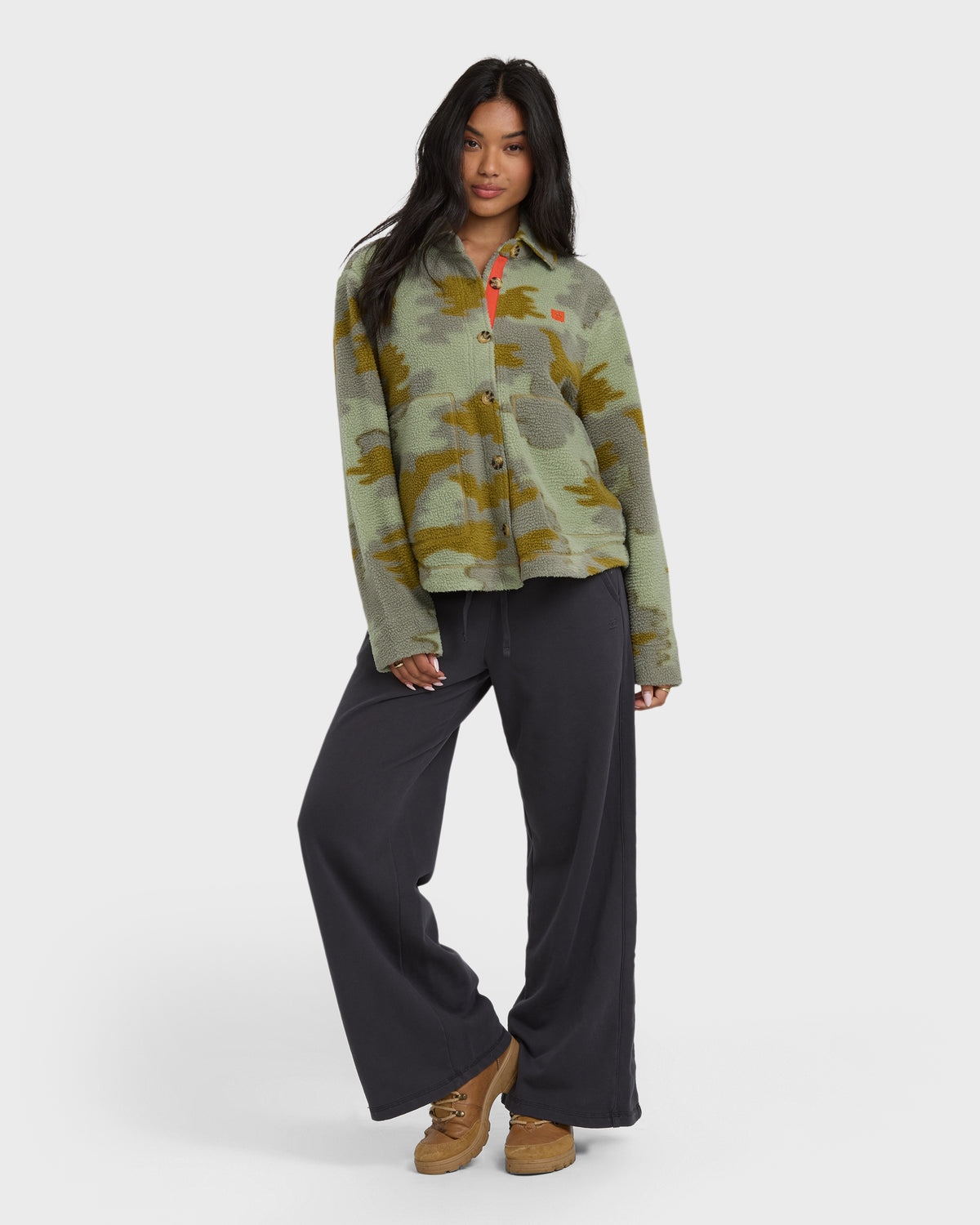 Camouflage sherpa shacket with olive and brown patterning, worn with black wide-leg pants and brown platform shoes.