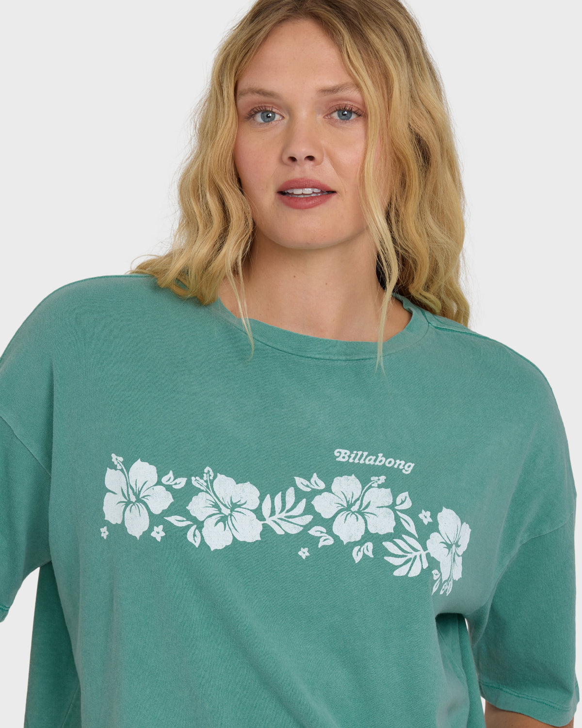 Island green short sleeve t-shirt with white floral design and "Billabong" text across chest.