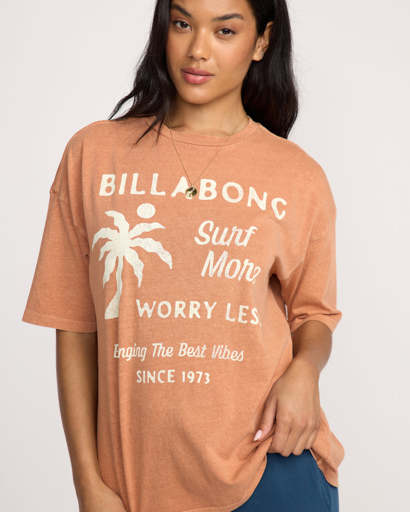 Sunburnt-colored short sleeve tee with white Billabong text and palm tree graphic on front.